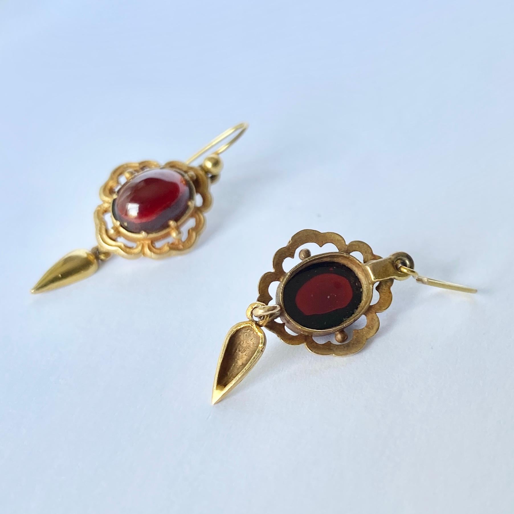 These gorgeous earrings hold smooth and glossy garnet stones set in 9carat gold. They have an ornate frame and a drop underneath.

Stone Dimensions: 8x11mm

Weight: 4.7g