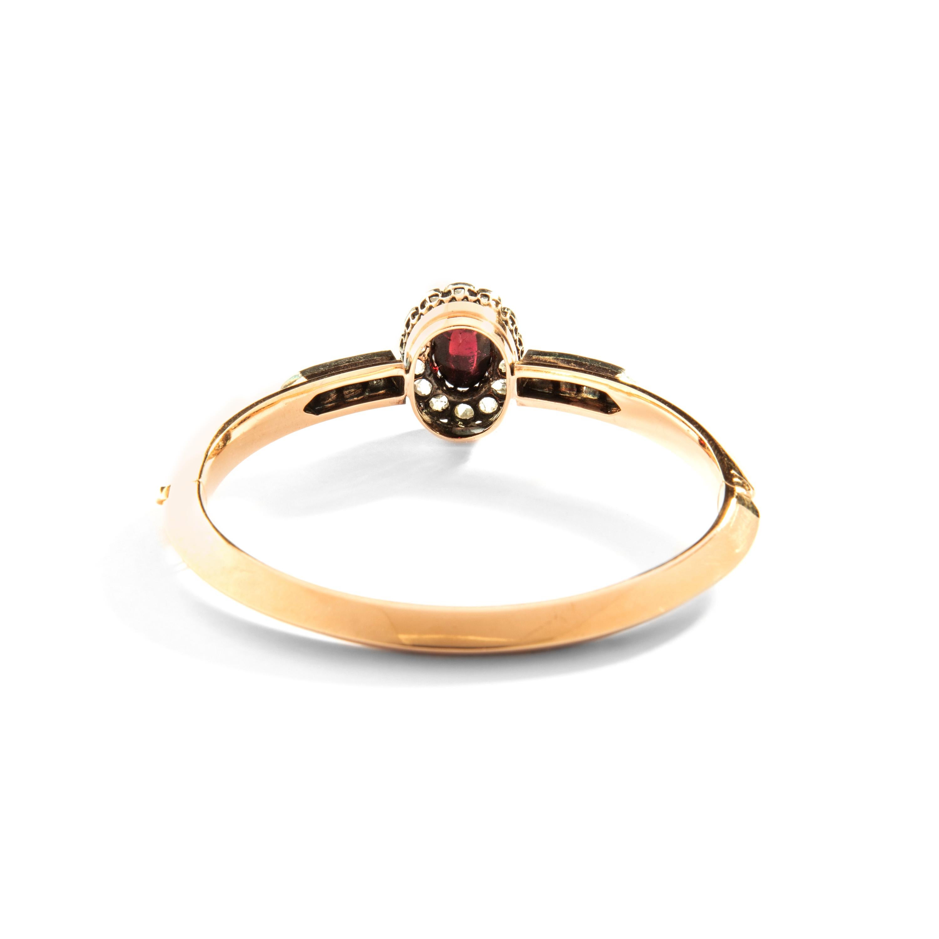 Grenat cabochon entouré de diamants taillés en rose, au centre d'un bracelet en or et argent 18 carats. 
Dimension : 2.36 x 2.16 pouces. 
Marques d'essai françaises. 
Fin du 19e siècle.