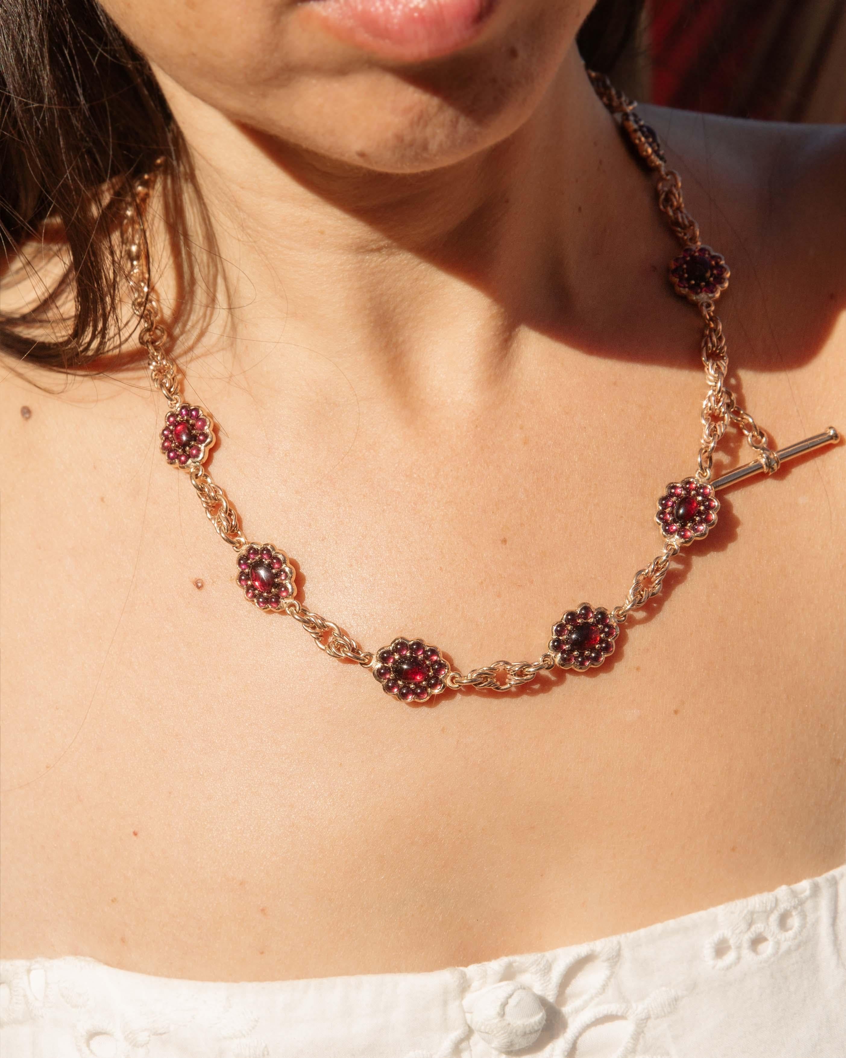 Embrace the allure of the 1920s with this exquisite Lune garnet fancy link cluster toggle necklace, crafted in luminous 9ct gold, and with a sprinkle of diamonds in the bar. Each warm garnet dances in harmony, capturing the light with a hypnotic