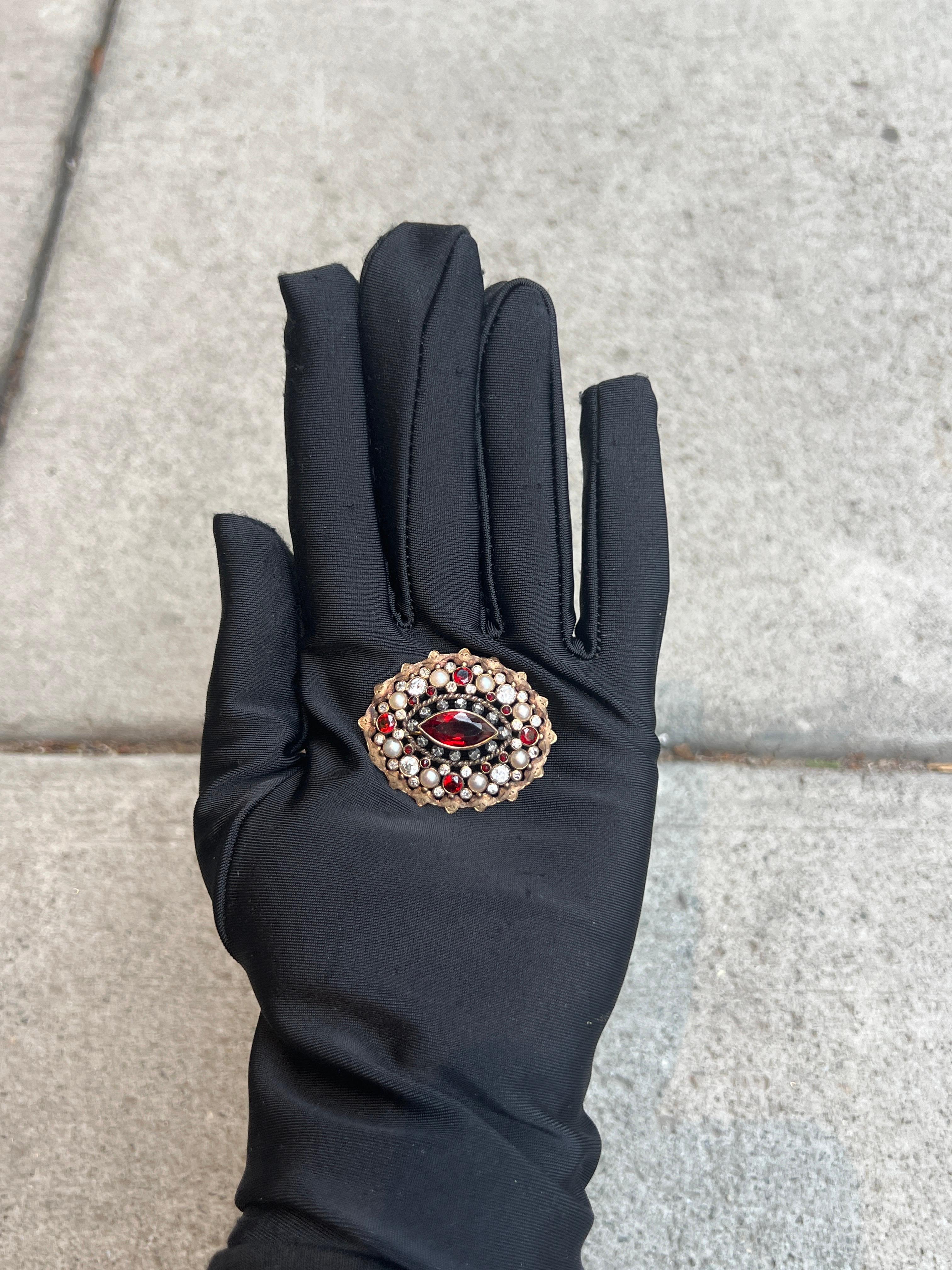 Antique Garnet & Pearl Brooch 

A brooch featuring a marquise cut red garnet surrounded by round cut red garnets & diamonds.

Measurements: 1.5