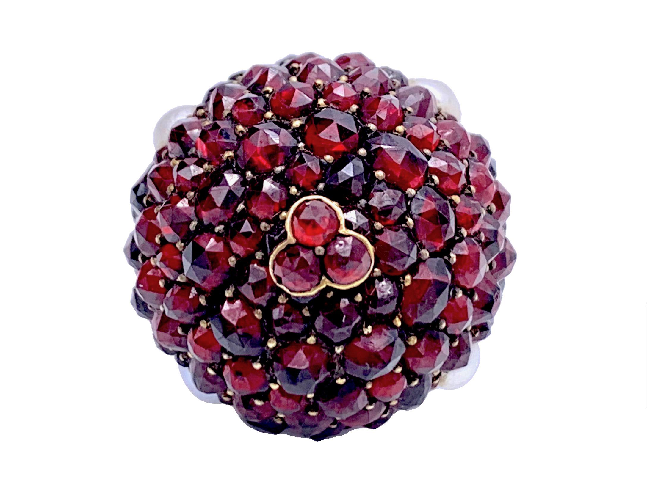  The charming pendant in the shape of a ball is set with facetted garnets and river pearls.