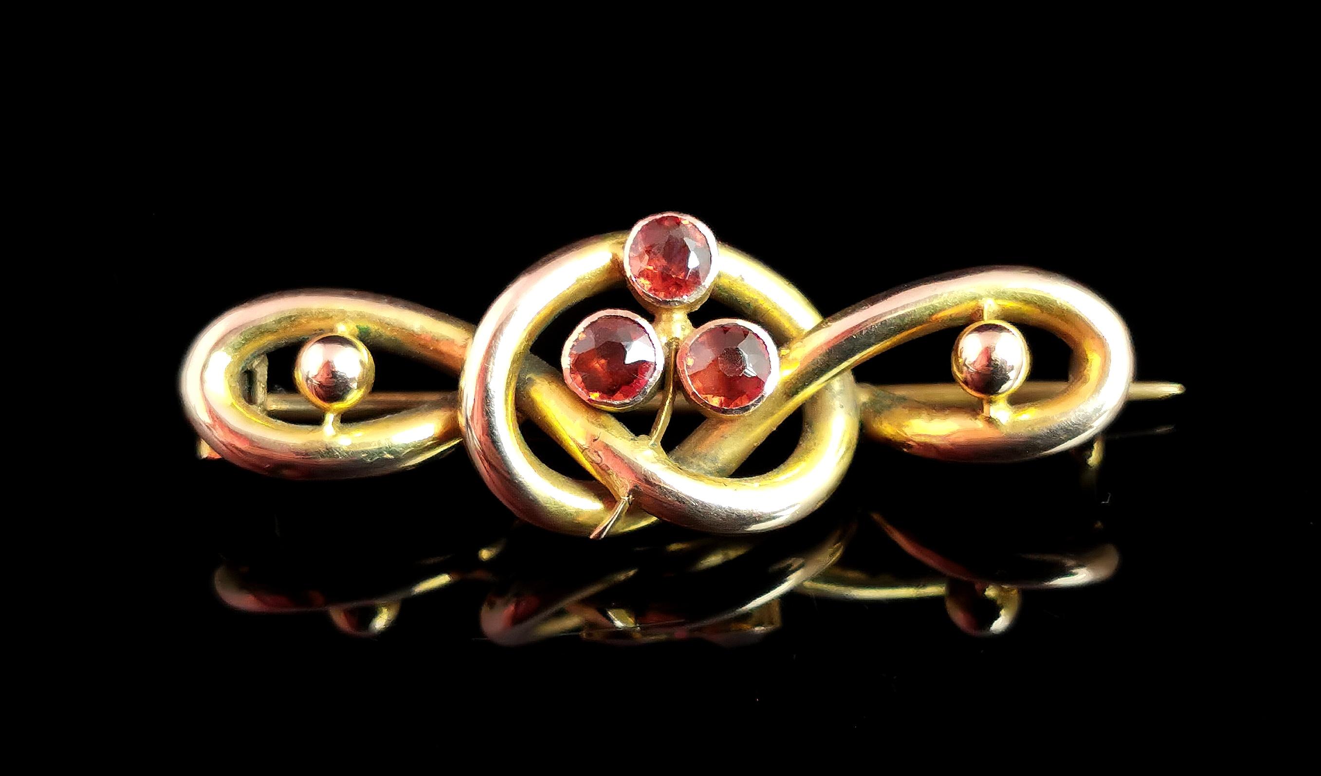 A superb antique, late Victorian shamrock and knot brooch.

Rich bloomed 9kt gold loops which swirl into a lovers knot in the centre provide the body of this brooch.

Combining two powerful symbols in jewellery the lovers knot is adorned with a