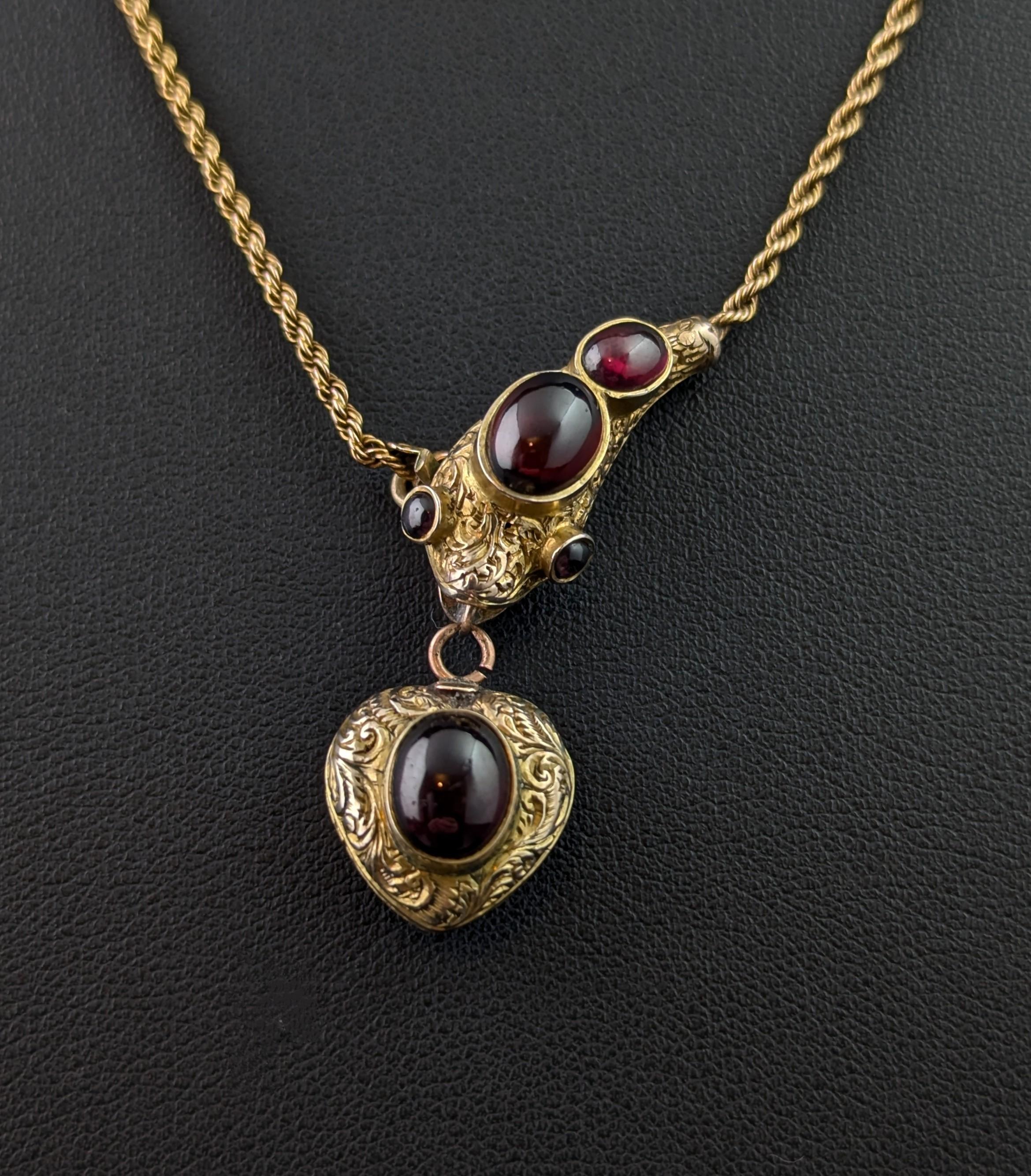 A beautiful and sumptuous antique, Snake necklace.

This necklace features a beautiful and highly detailed snake head pendant set with juicy, rich red, Garnet cabochon both to the head and the eyes.

The snake holds suspended in its mouth the