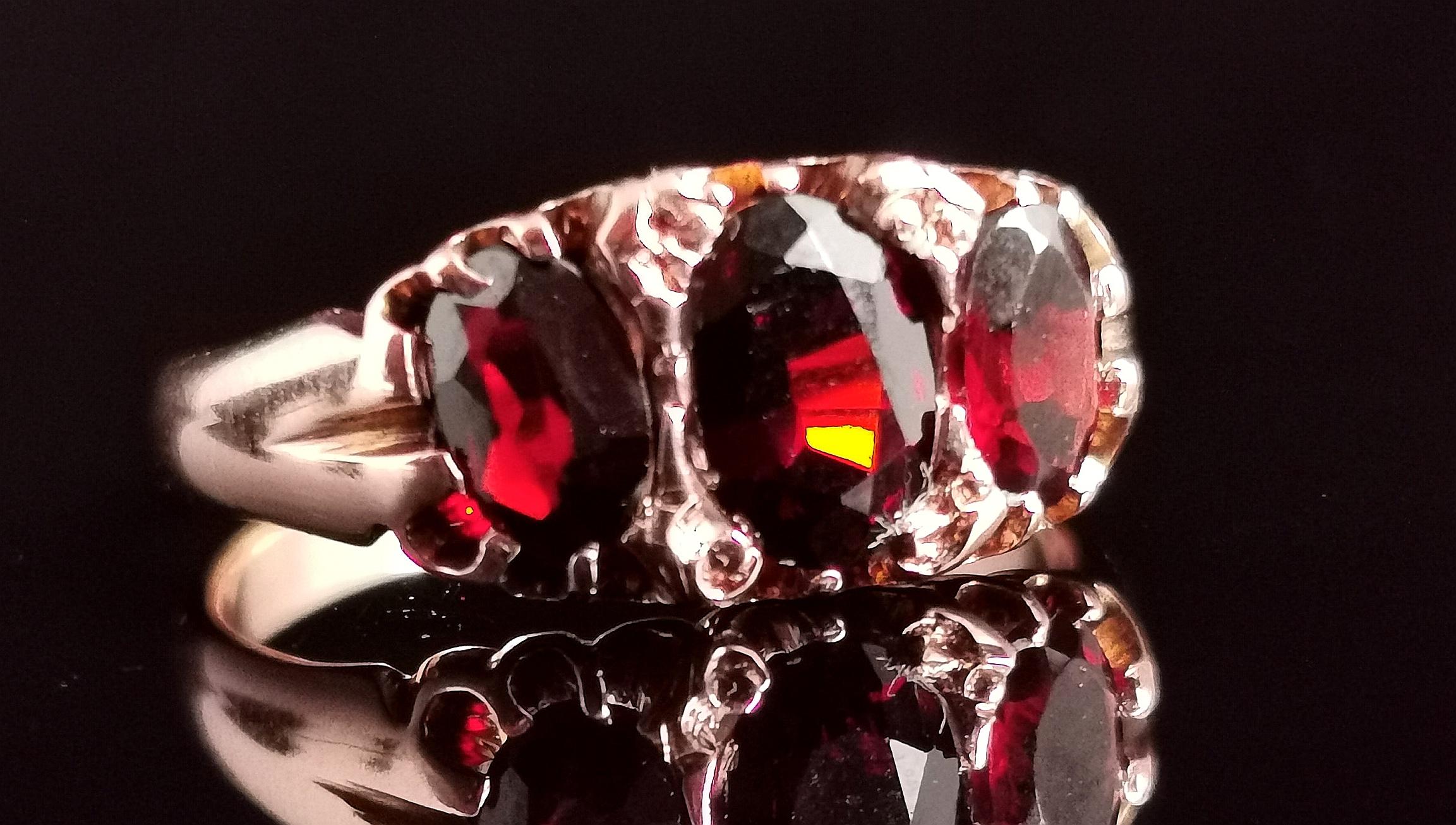 A beautiful antique Garnet three stone ring.

A chunky boat head style with three large, rich red oval cut garnets set to the front.

It has lovely rich rosey gold tones and a smooth polished band.

Lots of rich colour and a nice chunky face, this