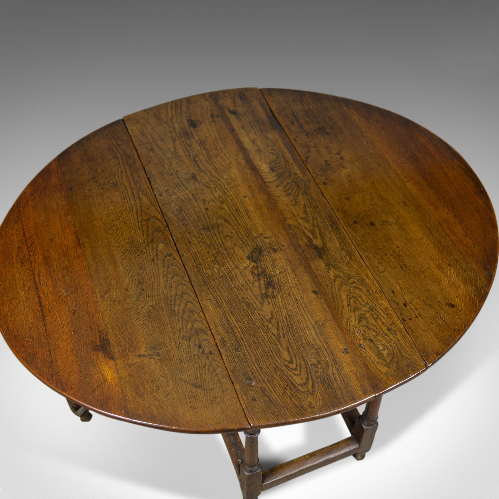This is an antique gate leg table. An English, Georgian, oak, country kitchen dining table dating to the late 18th to early 19th century, circa 1800.

Crafted from generously thick English oak
Grain interest throughout with a desirable aged