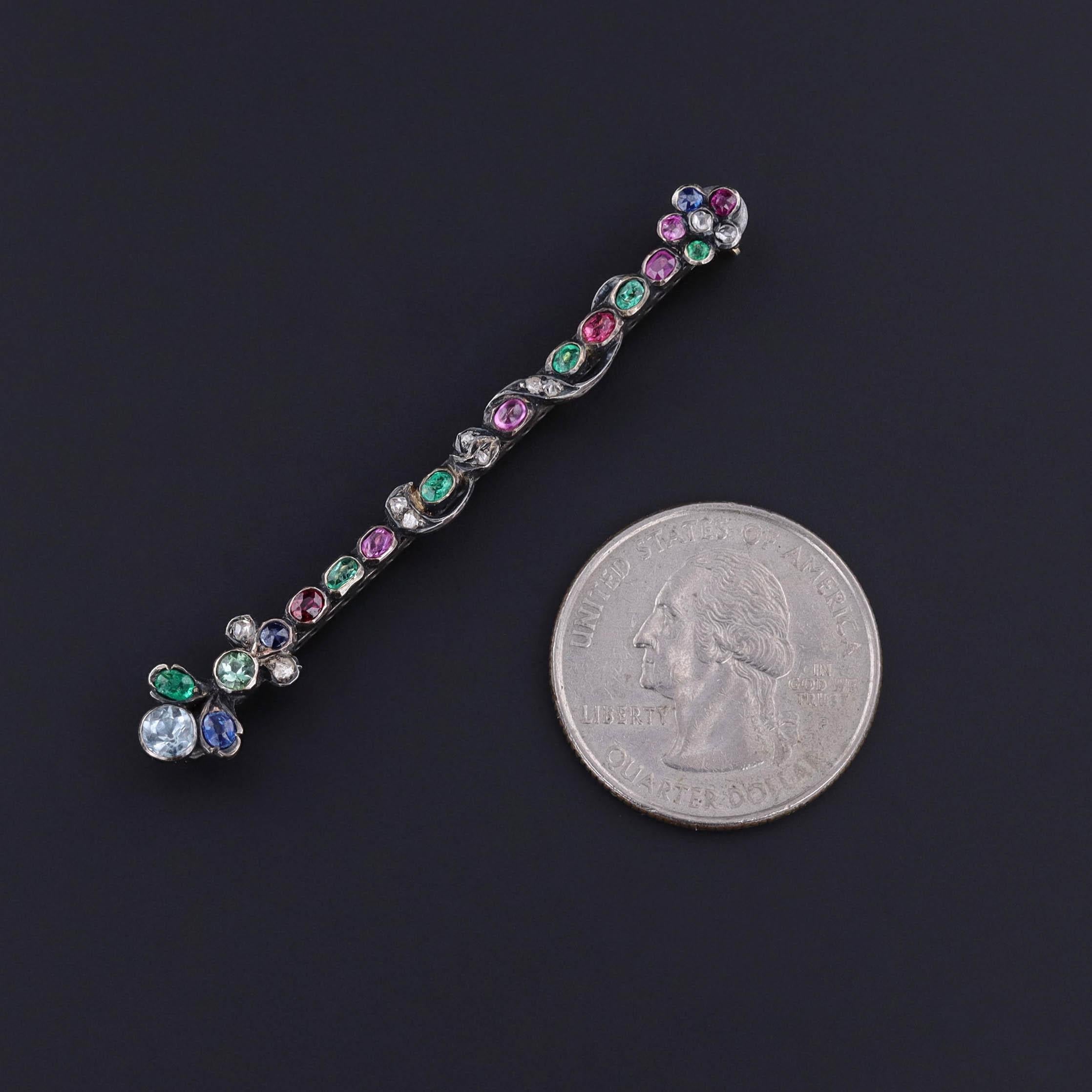 Esempio squisito di artigianato di inizio Ottocento, questa rara spilla di epoca georgiana (1800-1830 circa) mette in mostra una vibrante sinfonia di rubini naturali, smeraldi, zaffiri, acquamarine e diamanti, tutti incastonati a mano nell'argento