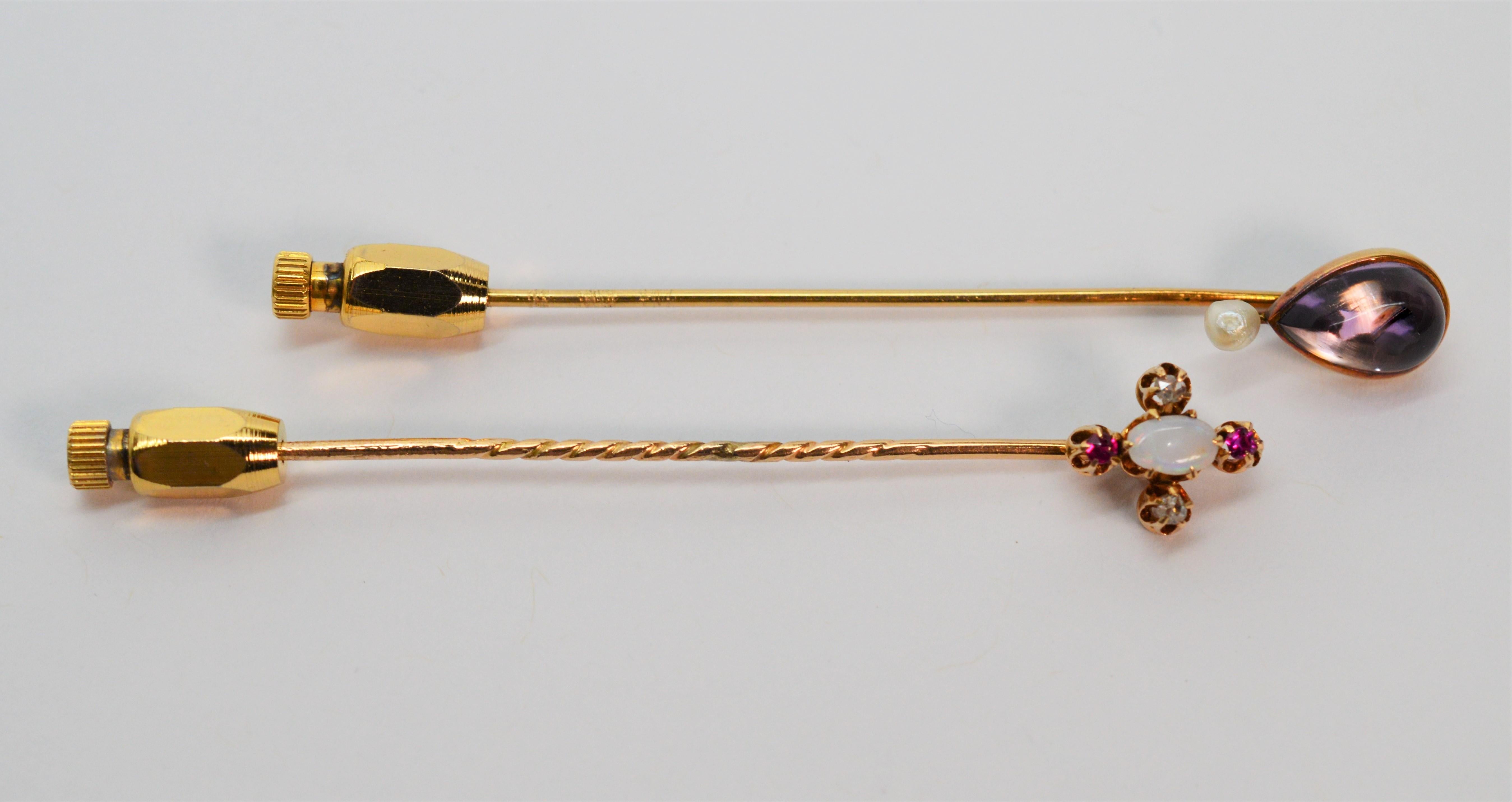 Twice the period finery, just because. This vintage fourteen karat 14K yellow gold stick pin duo includes one Art Deco opal, ruby and diamond stick pin and one stick pin with a pear shaped amethyst cabochon and pearl accent. Both pins are perfect