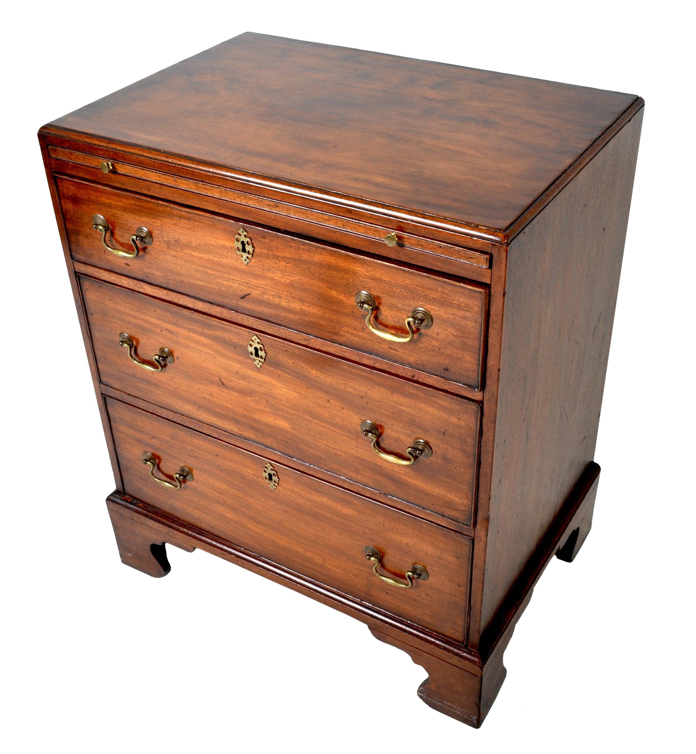Antique gentleman's 'Bachelor's' Georgian chest of drawers, circa 1760. Made of solid Cuban mahogany, the chest of unusual diminutive size and having a brushing slide to the top with three graduated drawers below. The chest standing on shaped