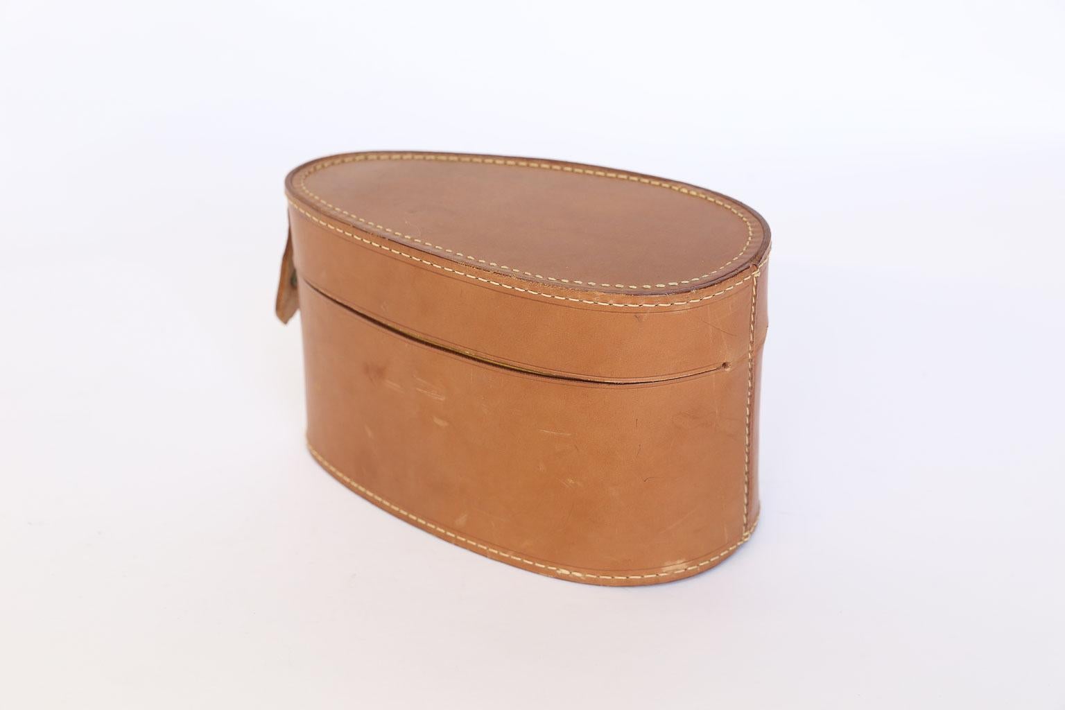 This is a beautiful leather gentleman's collar box. The lovely egg shape of the box makes it a unique accessory for your dresser or bookshelf. The leather and interior are in near perfect condition. The snap closure is missing a small piece so it