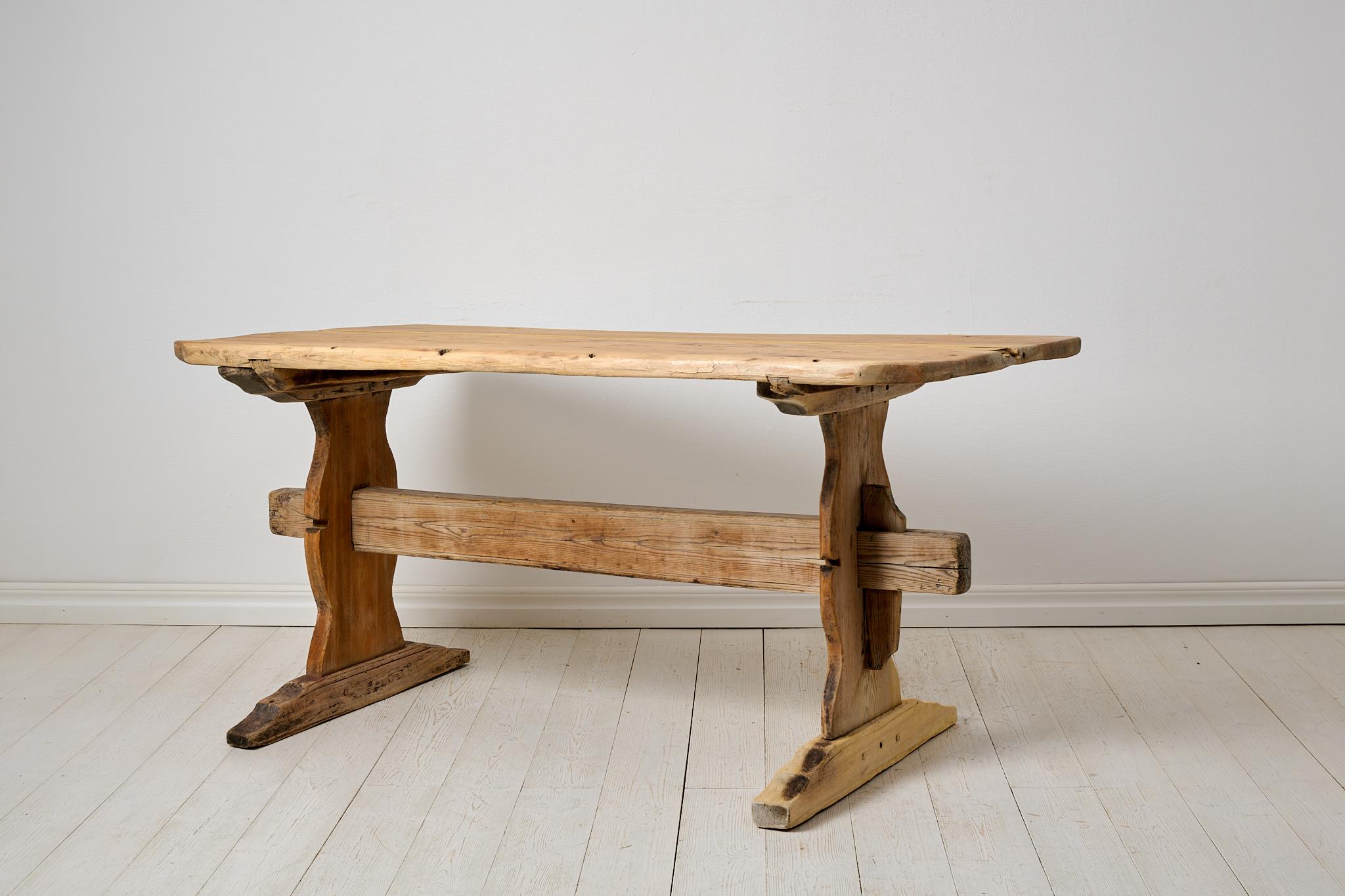Folk-Art-Bocktisch, Ess- oder Arbeitstisch aus Nordschweden. Der Tisch ist eine echte Antiquität und ungewöhnlich robust und charmant gemacht. Die Tischplatte ist dick und schwer und besteht aus nur 2 großen Holzbrettern. Es wurde um die Mitte des