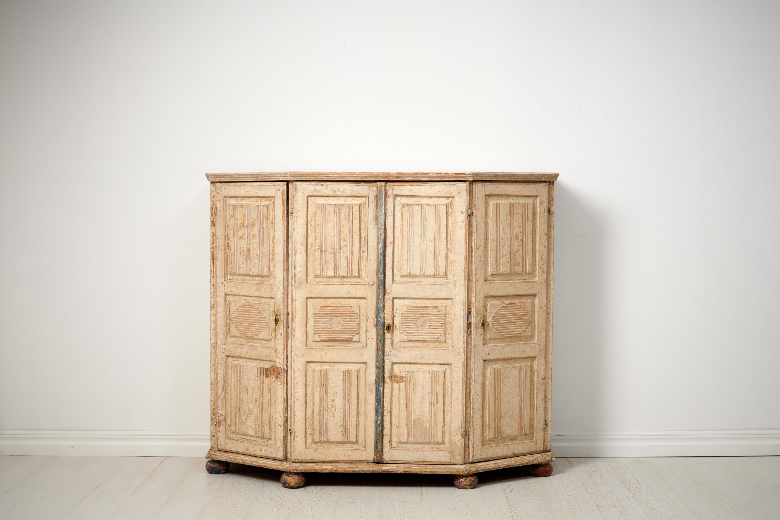 Antique genuine Swedish sideboard in gustavian style. The sideboard is a country house furniture made by hand in solid pine in northern Sweden around 1820. With carved wooden panels on the doors. The sideboard is brought to original paint from the