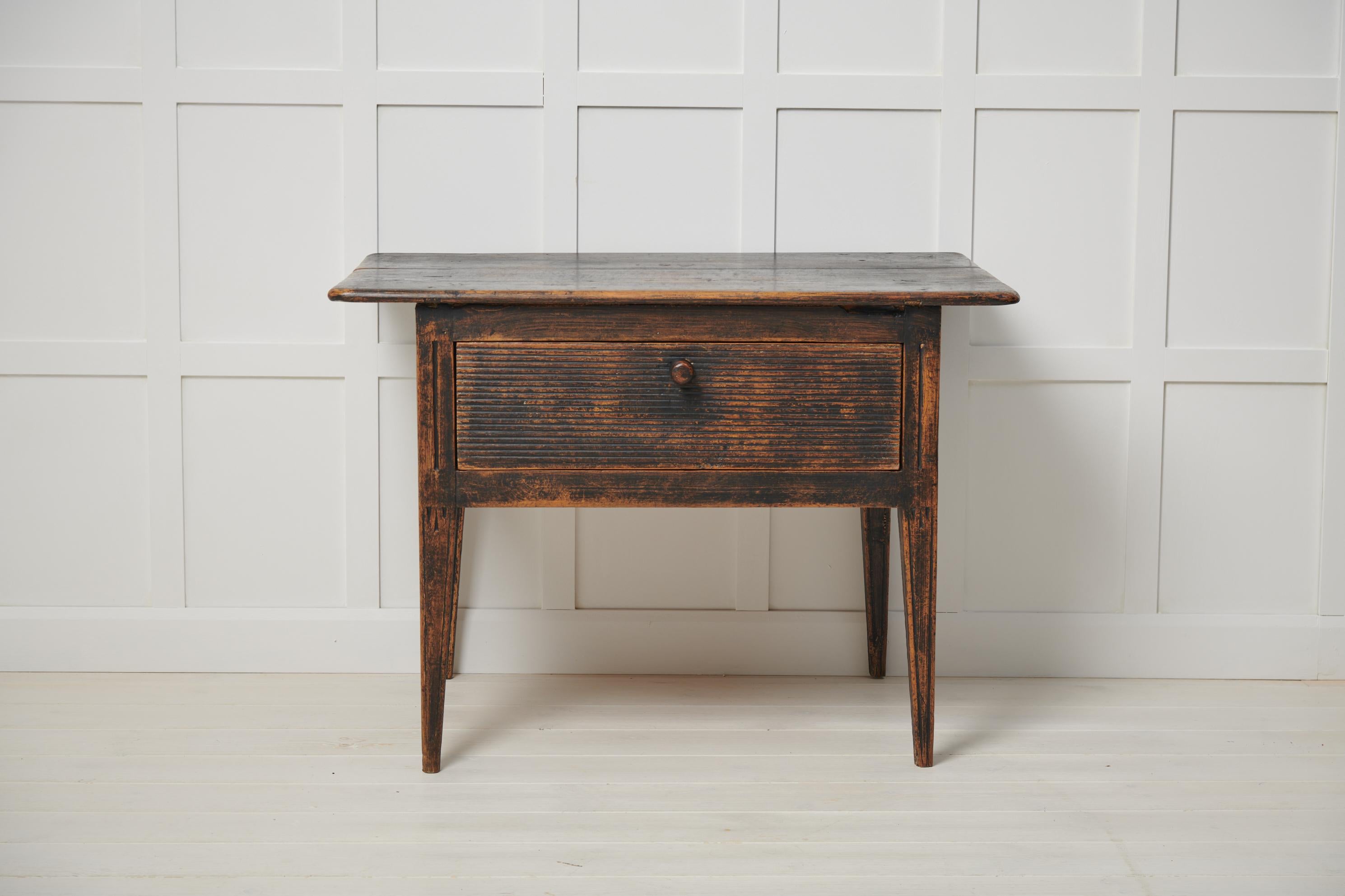 Genuine Swedish antique table in folk art from northern Sweden. The table is made by hand around 1840 from solid painted pine. The table has a large drawer with the original fluted front. Today it would work well as a coffee table or side table. The