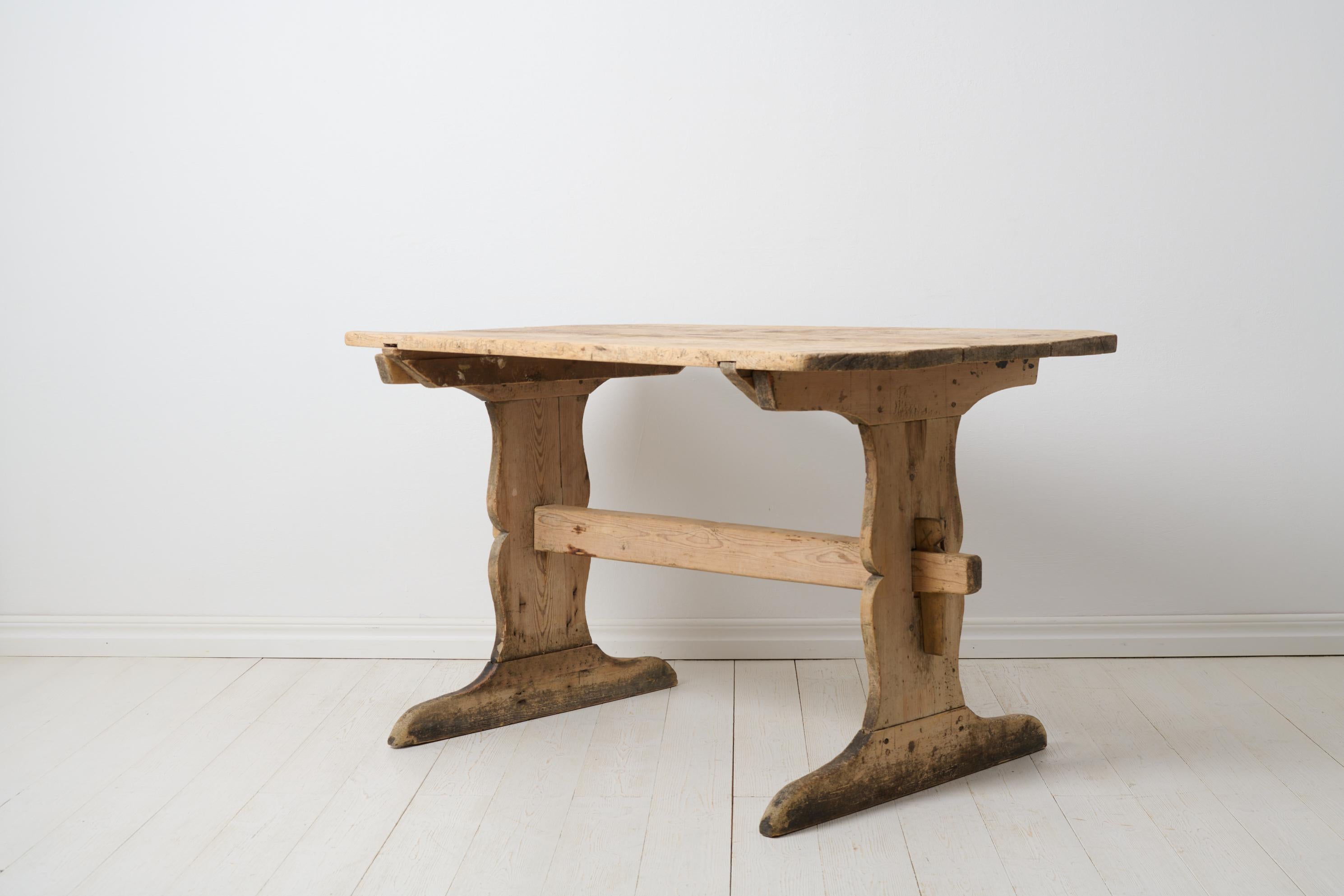 Antique country trestle table from northern Sweden made during the early 1800s. The table is a genuine antique and made by hand in solid pine. The construction is made completely without screws or nails. The table has never been painted and has a