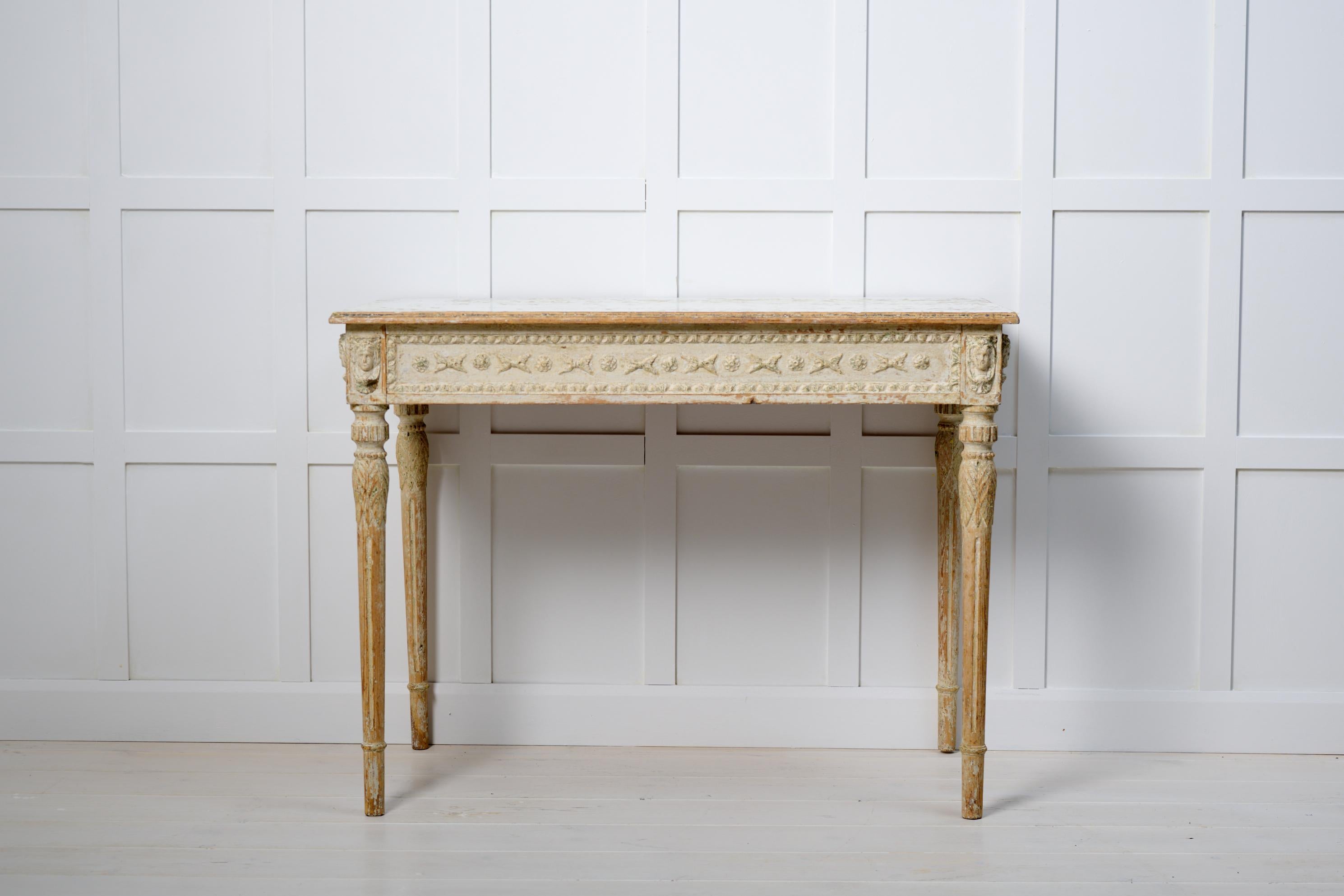 Swedish gustavian console table in painted pine. The table is made around 1790 to 1800 and has detailed carved wooden decor. The surface has been scraped by hand to the original paint which has created a rustic patina. The table is just over 200