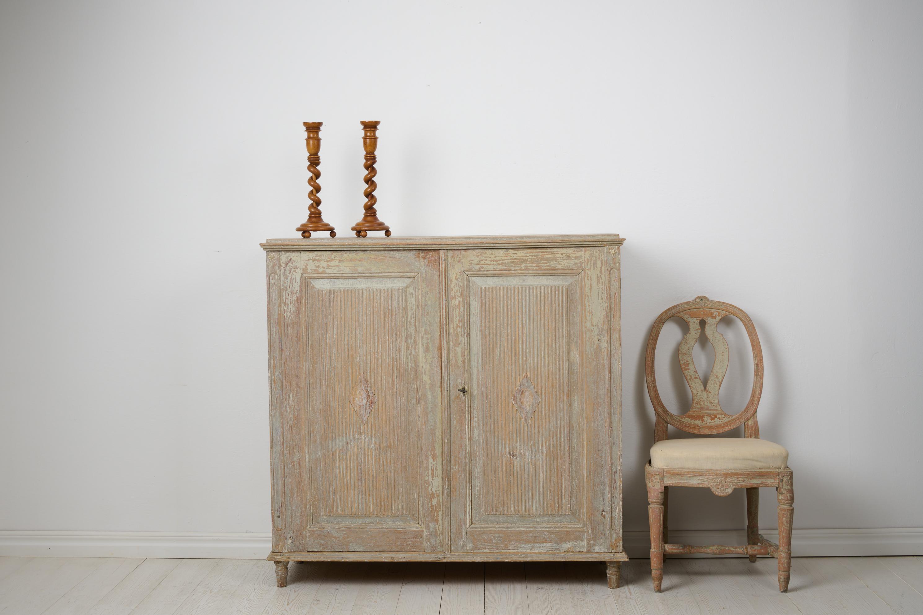 Swedish antique sideboard from the gustavian period. The sideboard is a genuine antique from around 1820 made by hand in solid pine in northern Sweden. Classic gustavian straight shape with double doors with ribbed diamonds on the front. The inside