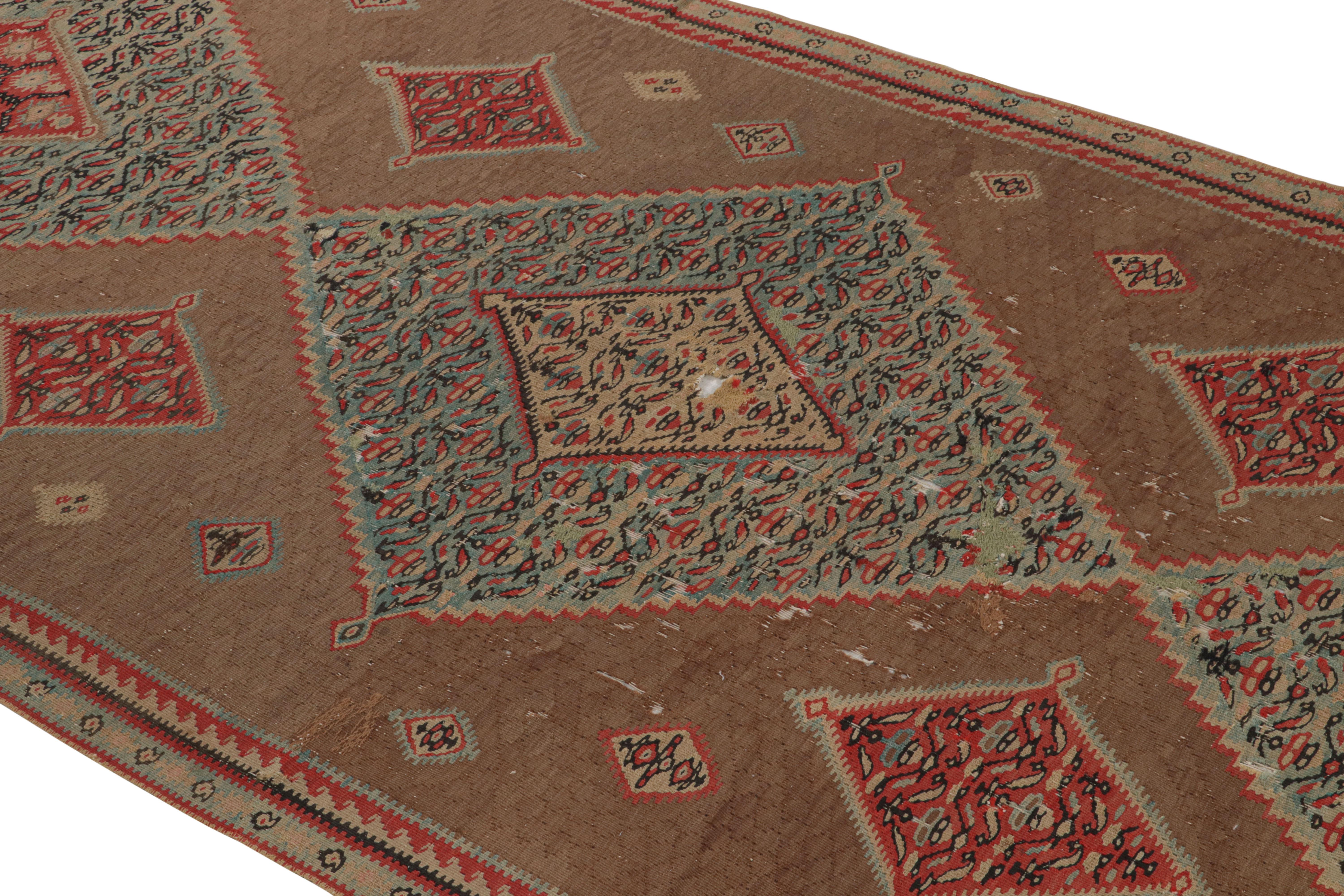 Flat-woven in high quality wool from Persia in 1880, this antique Persian Kilim Senneh runner enjoys a bold geometric series of aqua blue and red outlined diamond medallions, mirrored against a luminous brown field background within finely woven