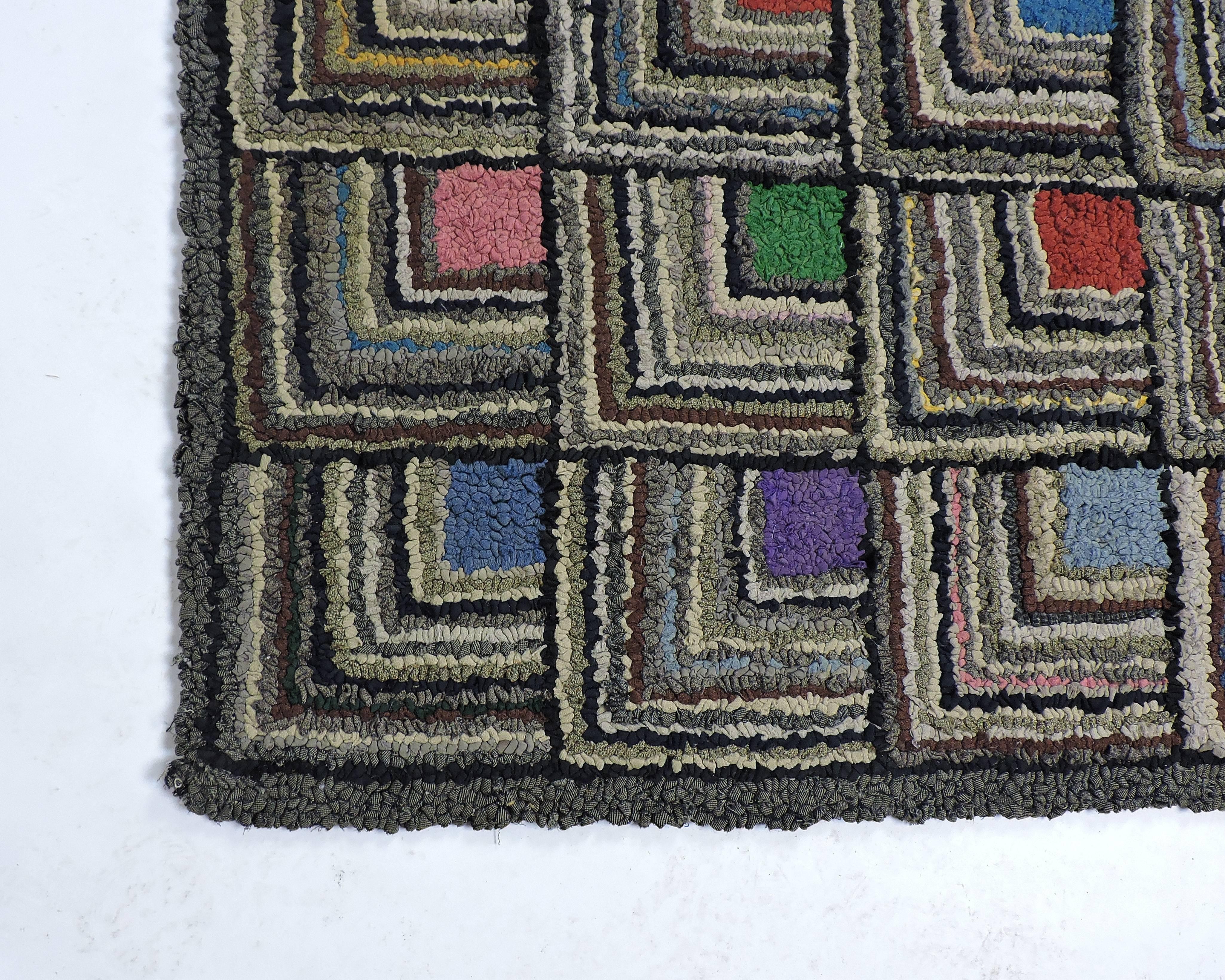 Striking example of a handmade hooked rug in a log cabin quilt pattern. With its modernist geometric pattern, vibrant colors and a three-dimensional look, this rug would fit into a variety of interior styles. Would also make a beautiful wall hanging.