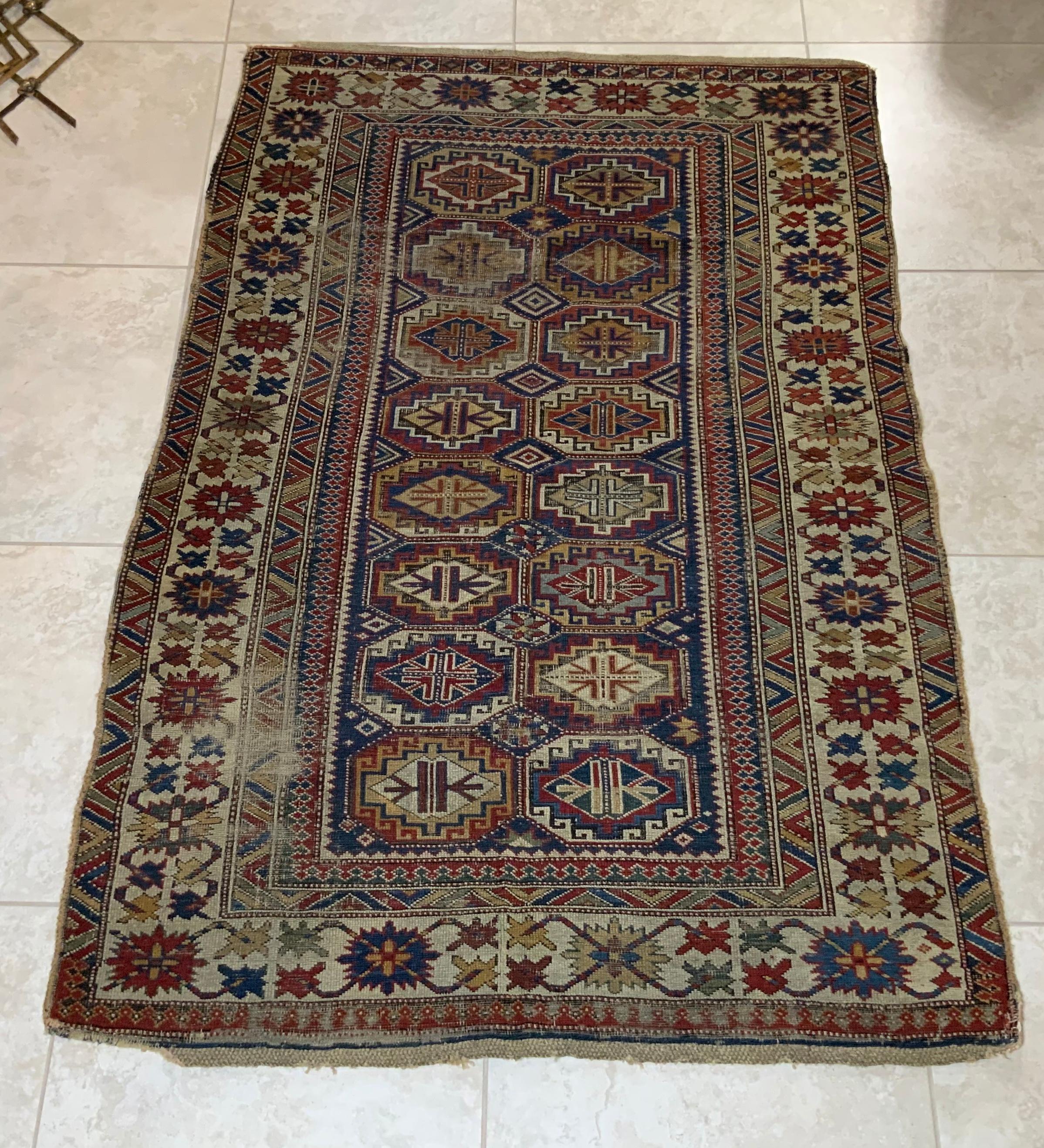 Elegant tribal Caucasian Kazak rug made of wool with beautifully executed geometric motifs of 16 center medallions surrounded by intricate Borders. The rug is tightly handwoven, very low pile and wear throughout, but still have the exceptional