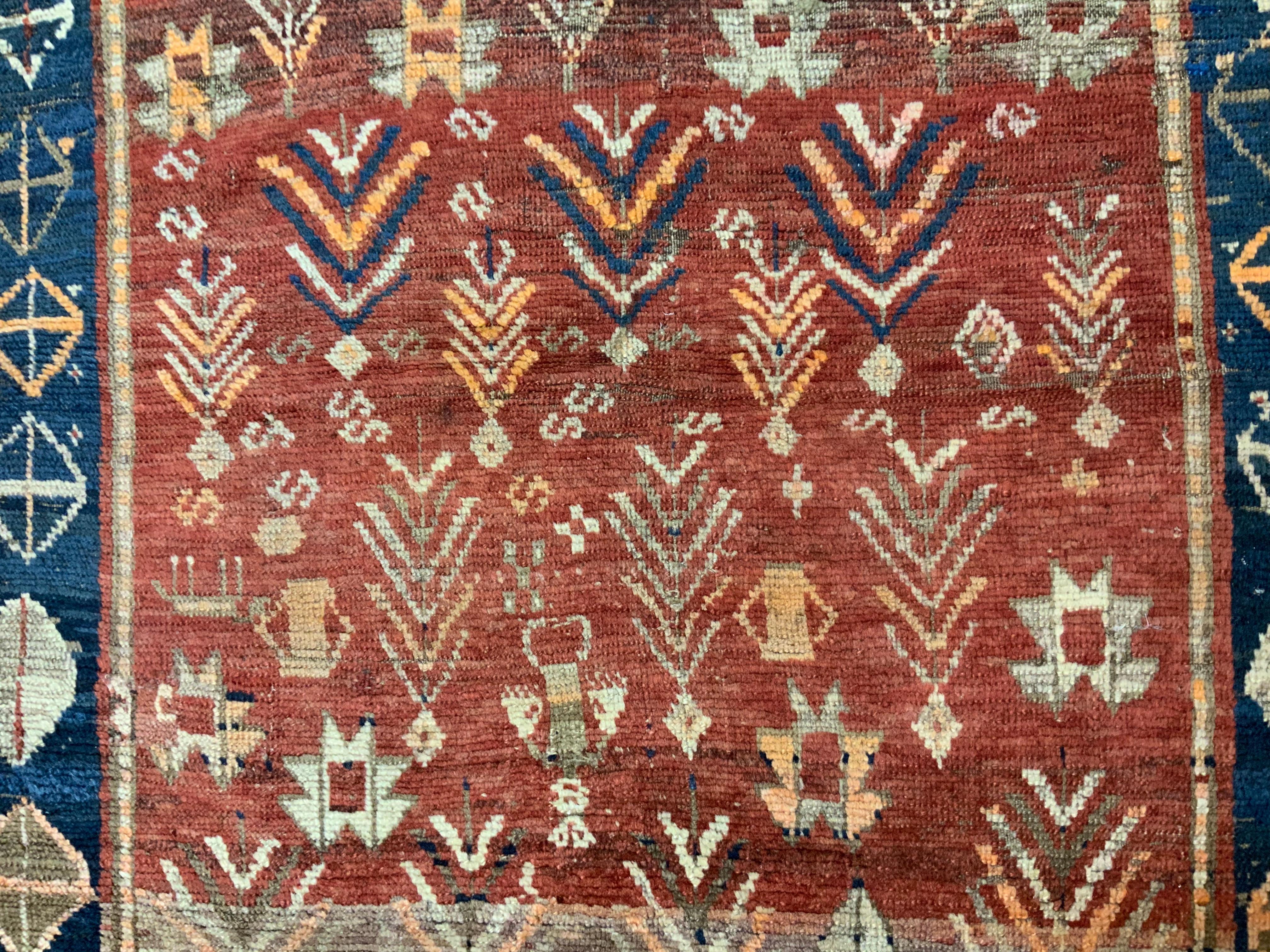 Elegant tribal Caucasian Kazak rug made of fine wool with beautifully executed geometric motifs of people and plants medallions surrounded by intricate blue Border. The rug handwoven by nomadic family . In some area very low pile and wear , Missing
