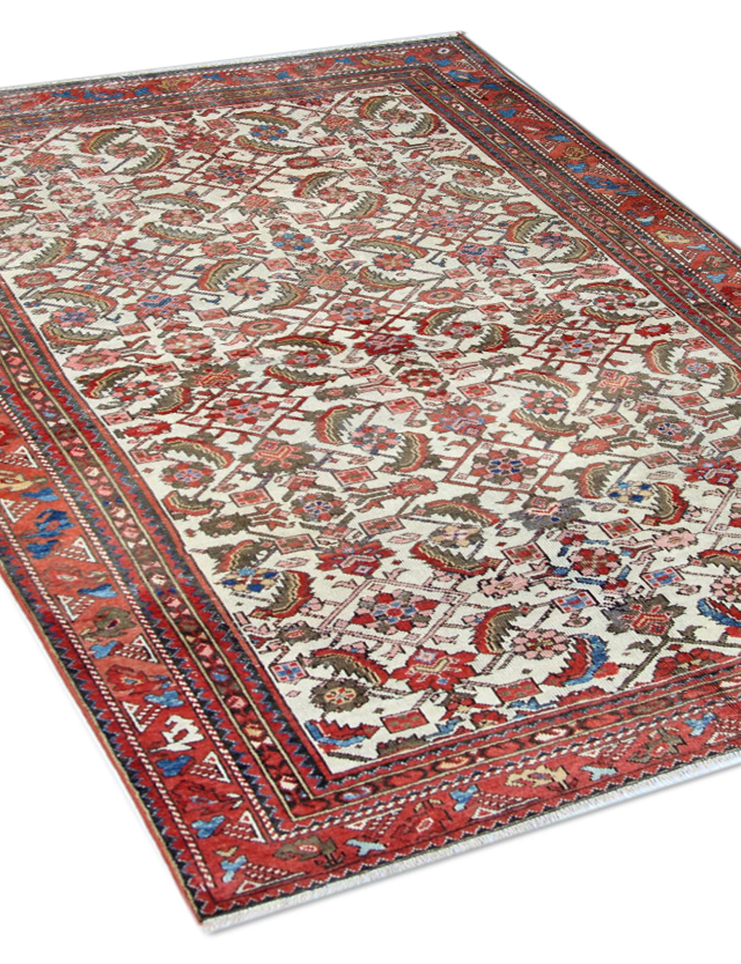 Handwoven with rich red and brown colours on an ivory background, the design features an intricate motif pattern that distinguishes this antique Malayer rug. A blend of oriental inspiration and tribal elements creates a unique, dynamic aesthetic in