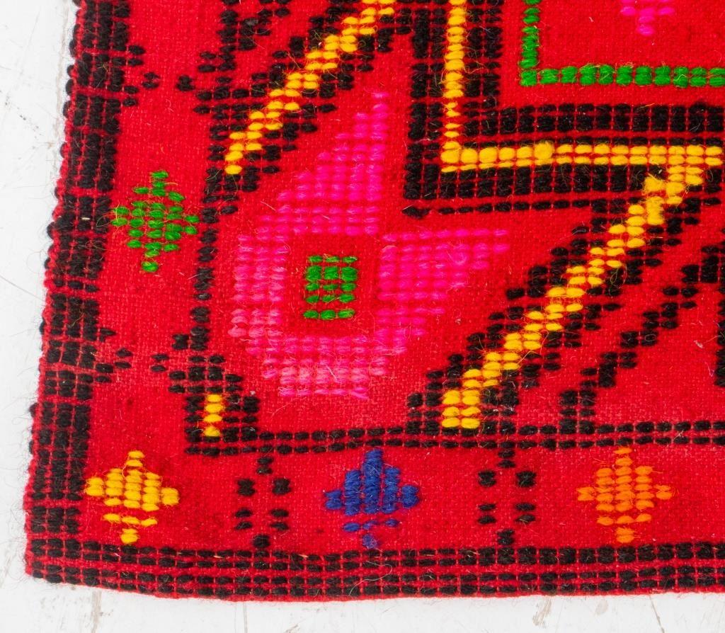 Polychrome red geometric star wool rug, with a tag stamped 