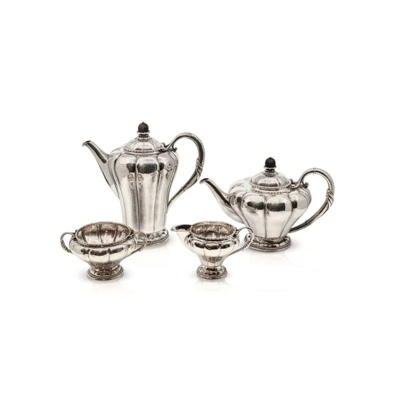 An antique 830 silver Georg Jensen tea and coffee service topped with ebony finials, design #3 by Georg Jensen from circa 1914. This pattern is seldom seen, very Art Nouveau in design.
This service includes –Coffee Pot, Teapot, Cream Jug, Sugar