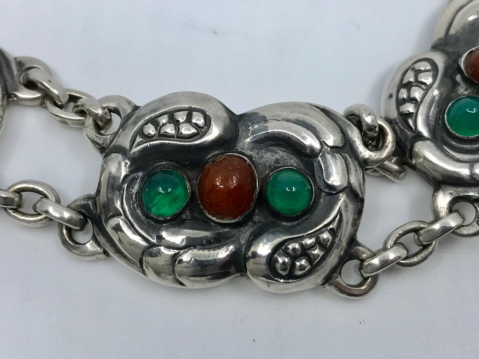 Antique silver Georg Jensen bracelet with cabochon set amber and green agate stones, design #1 by Georg Jensen from 1904.
Measures 7½” in length, the links are 7/8″ across (19cm, 2.1cm).
Antique Georg Jensen hallmarks from 1908-1914, 826s. Georg