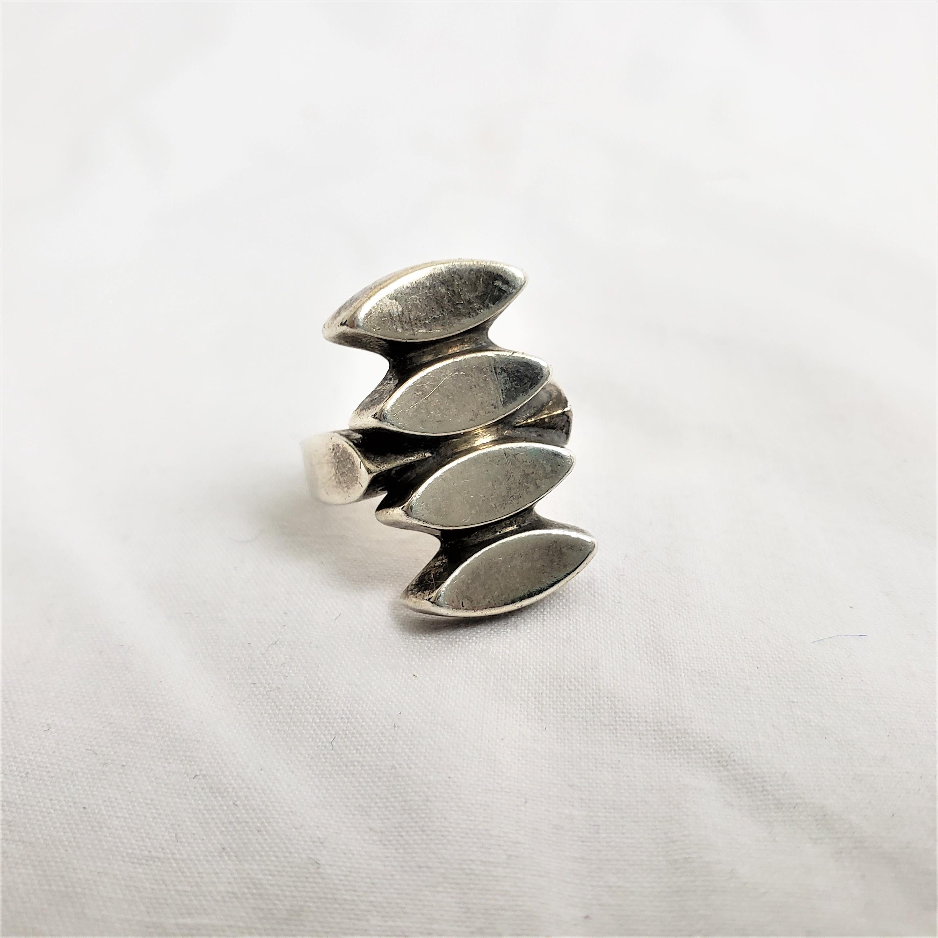 This ladies ring was made by the renowned Georg Jensen of Denmark in approximately 1920 in his period Art Deco style. The ring is composed of sterling silver and done with a geometric design. The rign is clearly signed with Geprg Jensen maker's