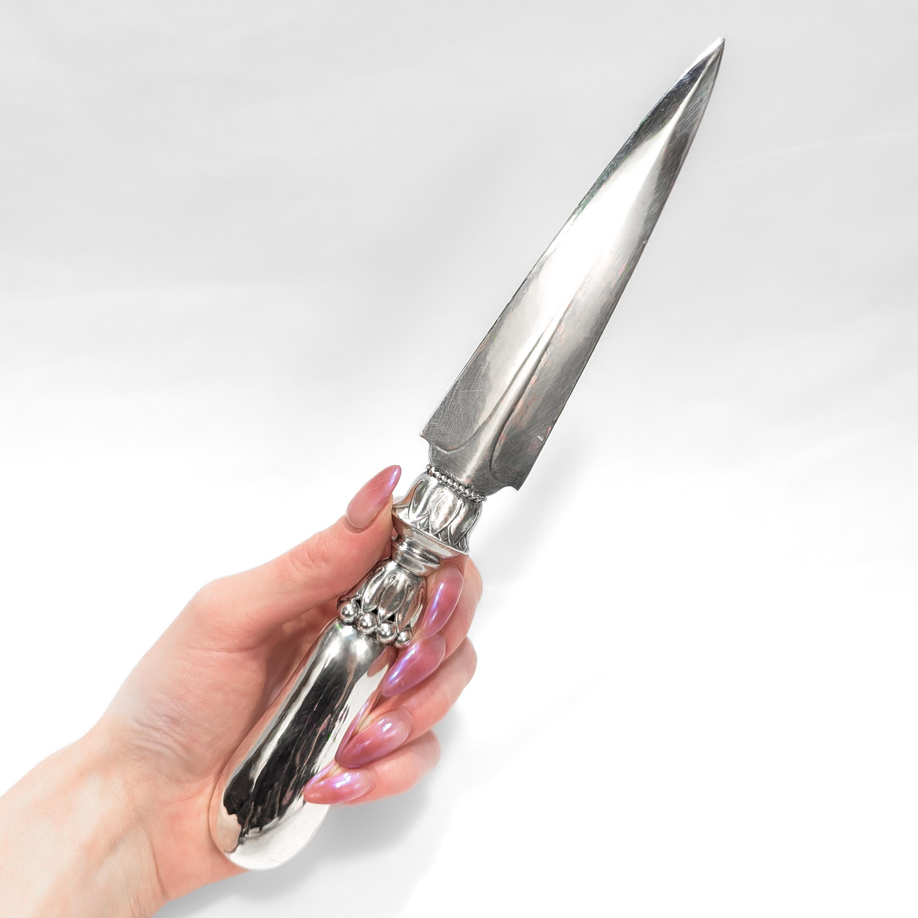 A fine Danish Modern letter opener.

In sterling silver.

By Georg Jensen.

Ornamental Pattern no. 121.

With a hand-hammered handle and a tapered blade.

Fully marked to one side of the blade.

Simply wonderful Georg Jensen design!

Date:
Early