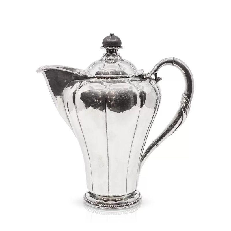Vintage 830 silver Georg Jensen pitcher with removable lid topped with an ebony finial, design #3 by Georg Jensen from circa 1914.

Additional information:
Material: 830 silver
Styles: Art Nouveau
Hallmarks: Antique Georg Jensen hallmarks from