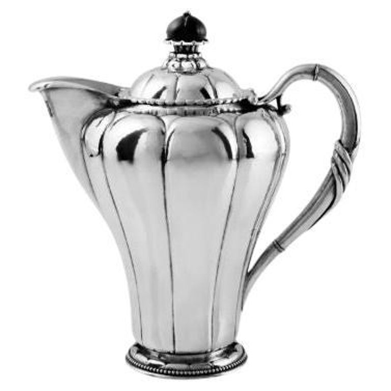 https://a.1stdibscdn.com/antique-georg-jensen-silver-lidded-pitcher-3-for-sale/22569652/f_366372721697454419790/f_36637272_1697454420126_bg_processed.jpg?width=768
