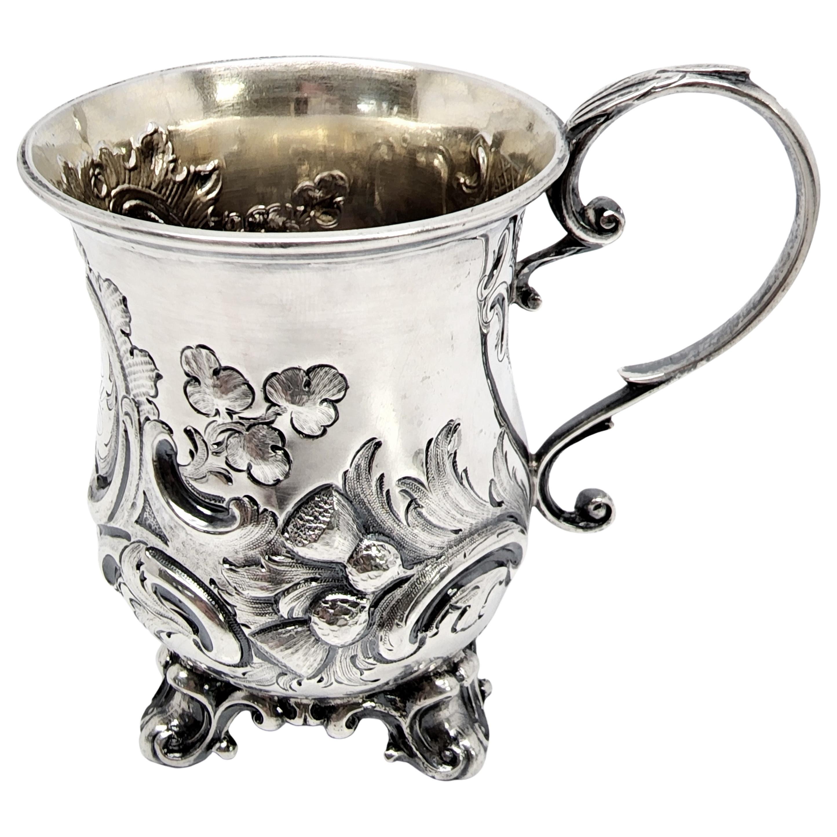 Antique sterling silver cup with gold wash interior by George Angell of London, England, circa 1854.

Engraving appears to be Mijs Stell

Repousse flower and scroll design cup featuring scroll feet and a delicately curved handle with gold washed