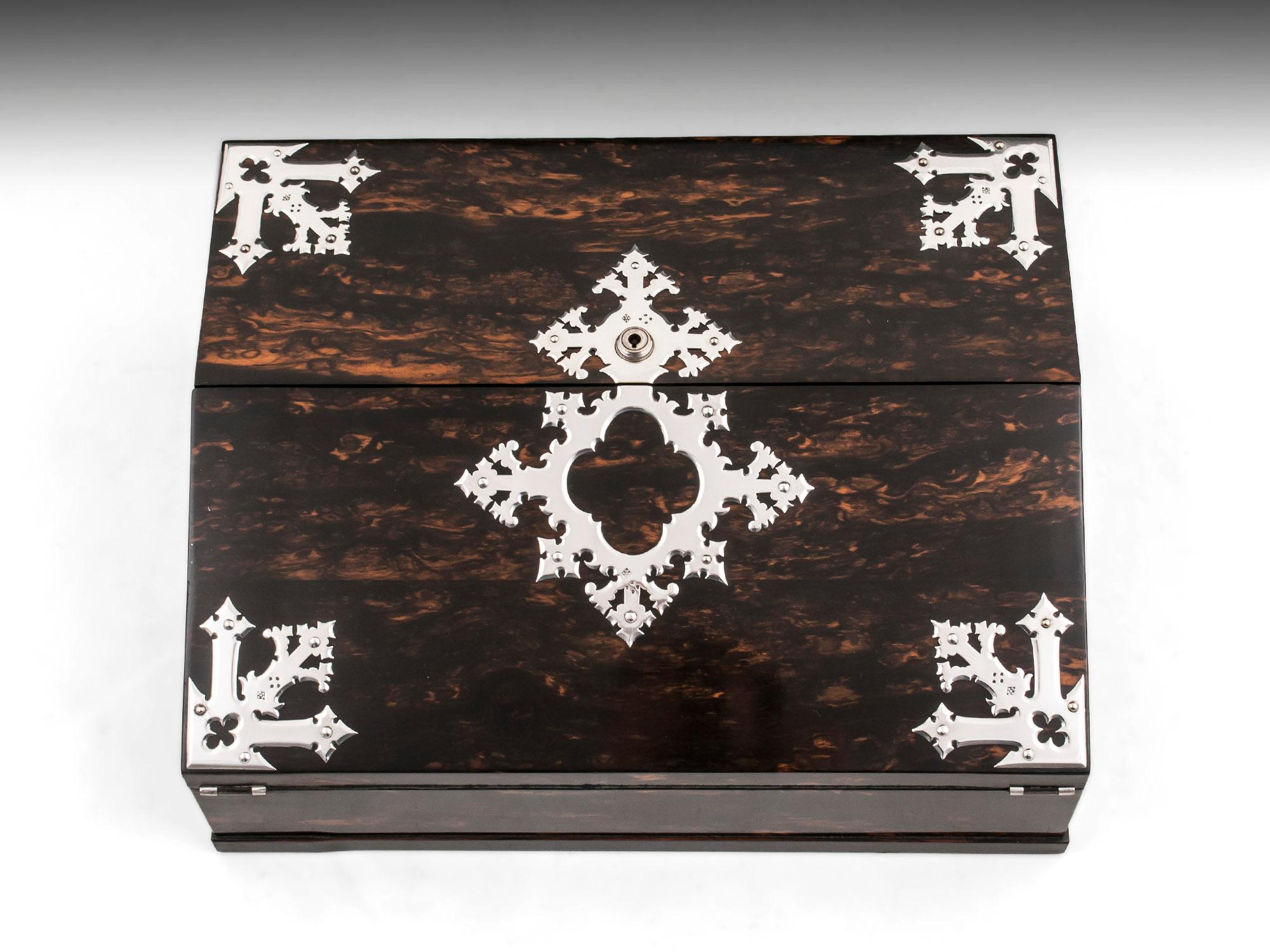 An unusual and rare design Writing Box by renowned cabinetmakers G.Betjemann & Sons, retailed by Toulmin & Gale, London. Veneered in beautiful figured exotic coromandel, complemented by a stunning satinwood interior. With ornate sterling silver