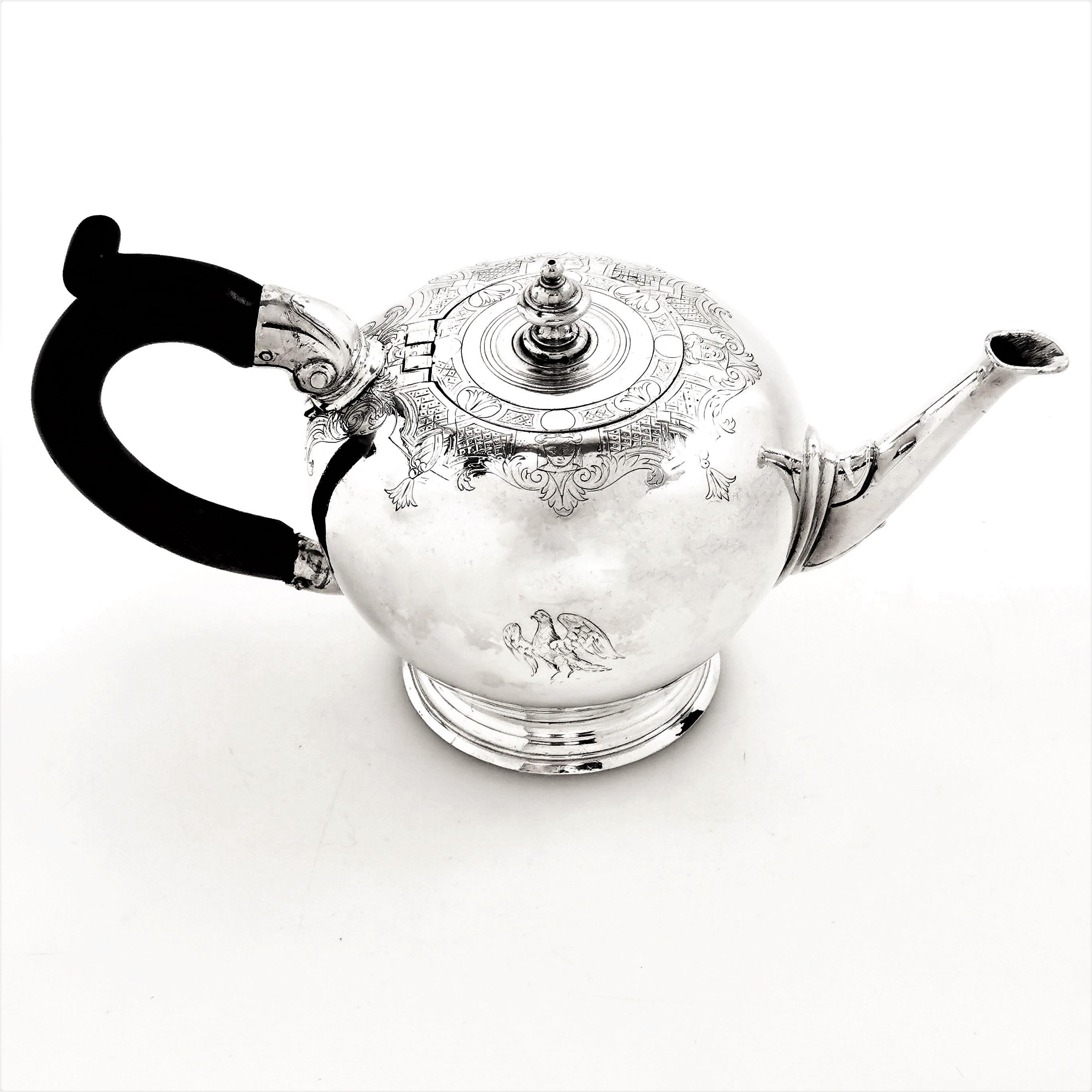 A beautiful Antique George I sterling Silver Teapot featuring a lovely delicate engraved band where the body and lid meet. This early Georgian Bachelor sized Teapot has a wooden handle and stands on a spread foot. The Teapot has a small crest