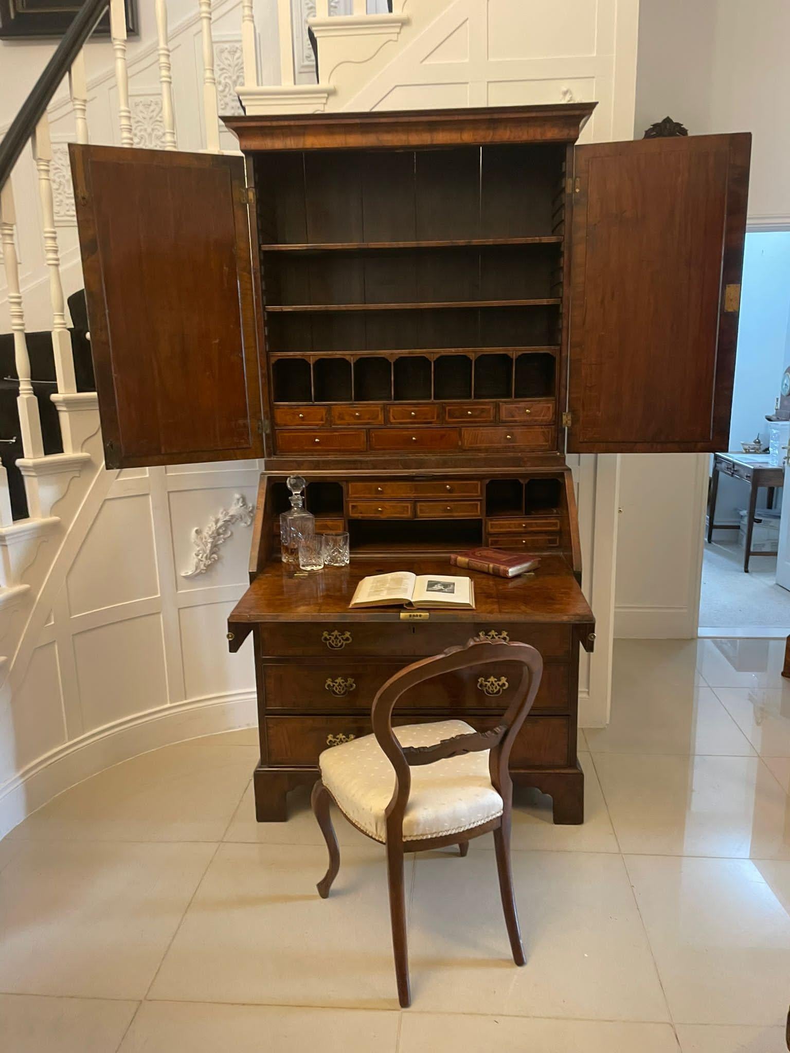 Antique George I quality figured walnut bureau bookcase having a shaped cornice above a pair of walnut doors with original plate mirrors opening to reveal a fitted interior and two adjustable shelves above a figured walnut fall opening to reveal a