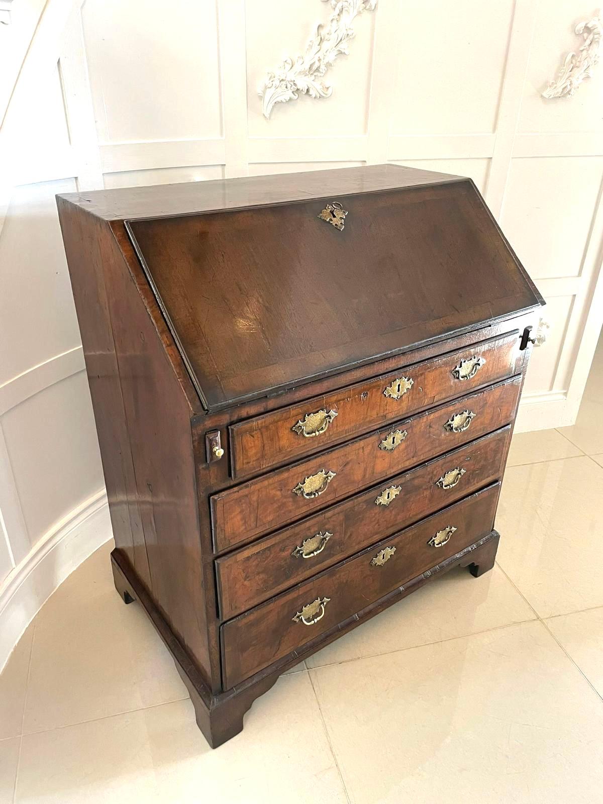 Bureau ancien en noyer figuré de qualité George I à incrustation de chevrons, avec une chute en noyer à incrustation de chevrons s'ouvrant pour révéler un intérieur aménagé comprenant 4 tiroirs, 6 trous de pigeon, une porte et un puits, 4 longs