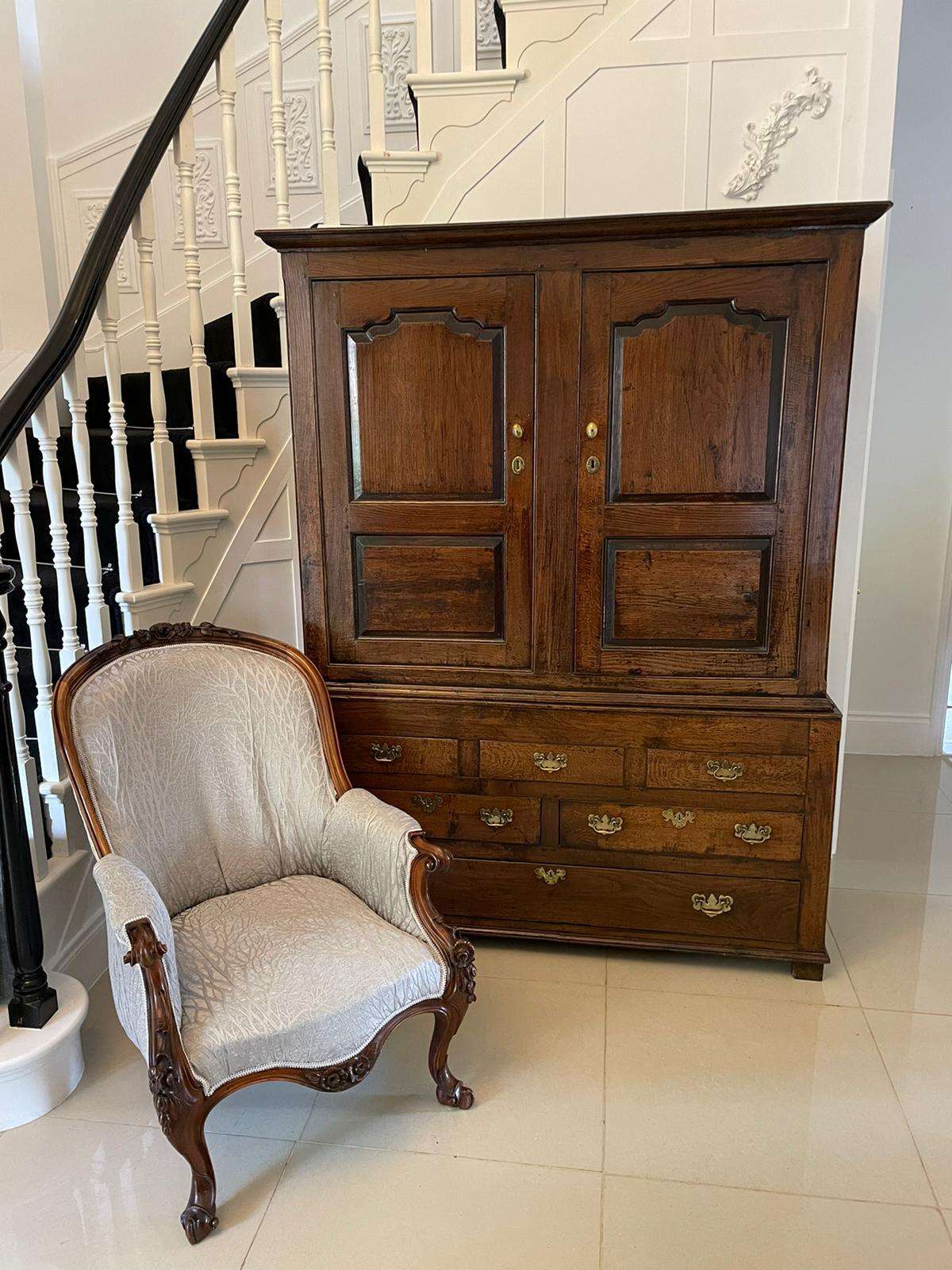 Antique George I quality oak livery cupboard having a shaped moulded cornice above a pair of quality oak fielded panelled doors opening to reveal a large storage/hanging compartment having the original turned oak pegs above five dummy drawers 1 long