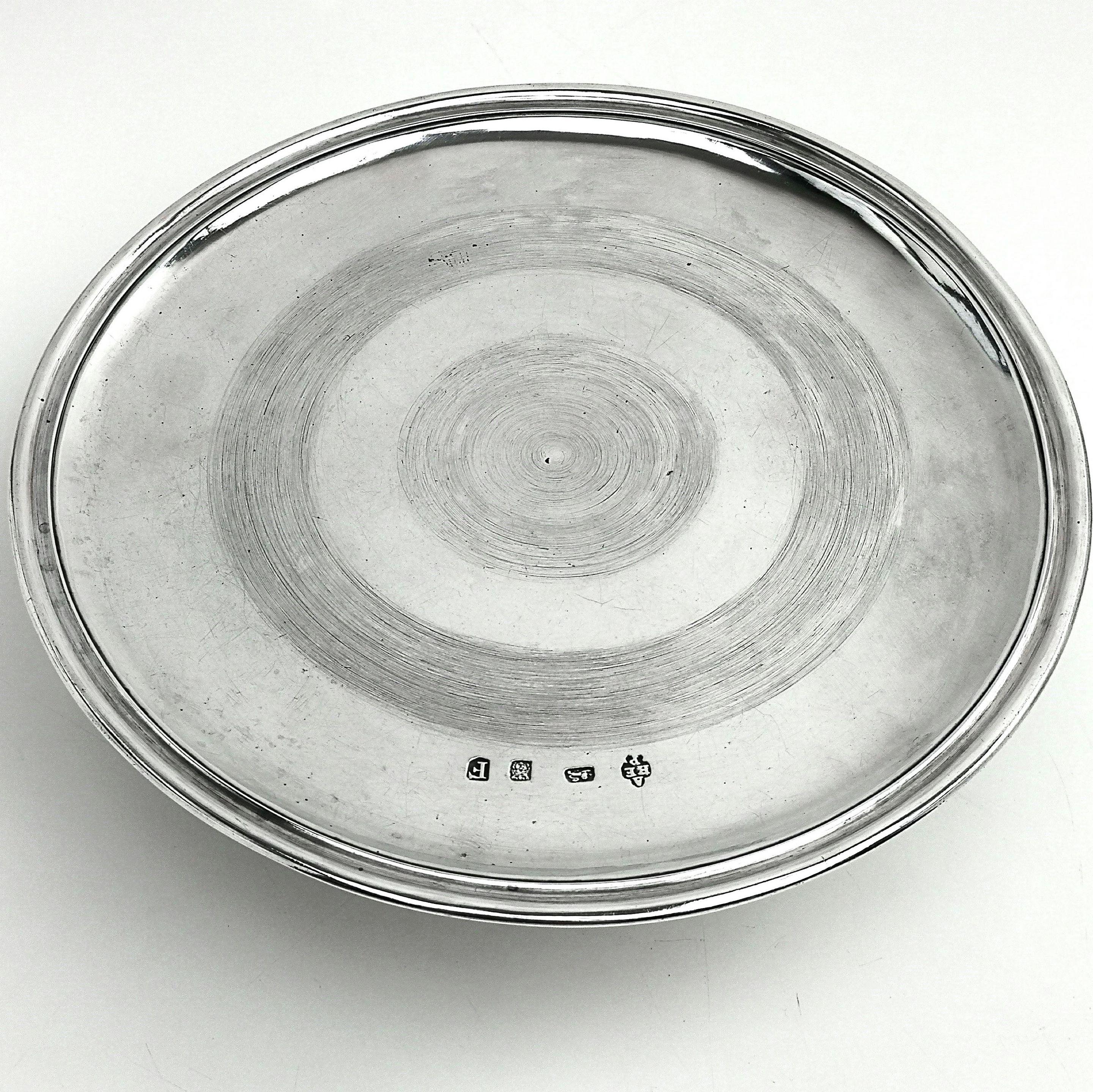 A lovely Antique George I solid Silver Tazza. The flat dish stands on a tall spread pedestal foot. This simple, elegant style is typical of the early Georgian period, although the circular texturing in the centre is unusual.
 
 Made in London in