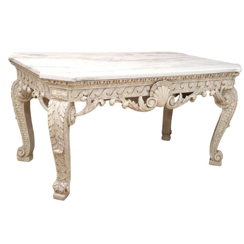 A magnificent George II marble top console table with rococo carved and painted solid wood base. The table features Italian white marble sitting atop a carved and painted antique white frame. The apron is carved with multiple motifs including egg