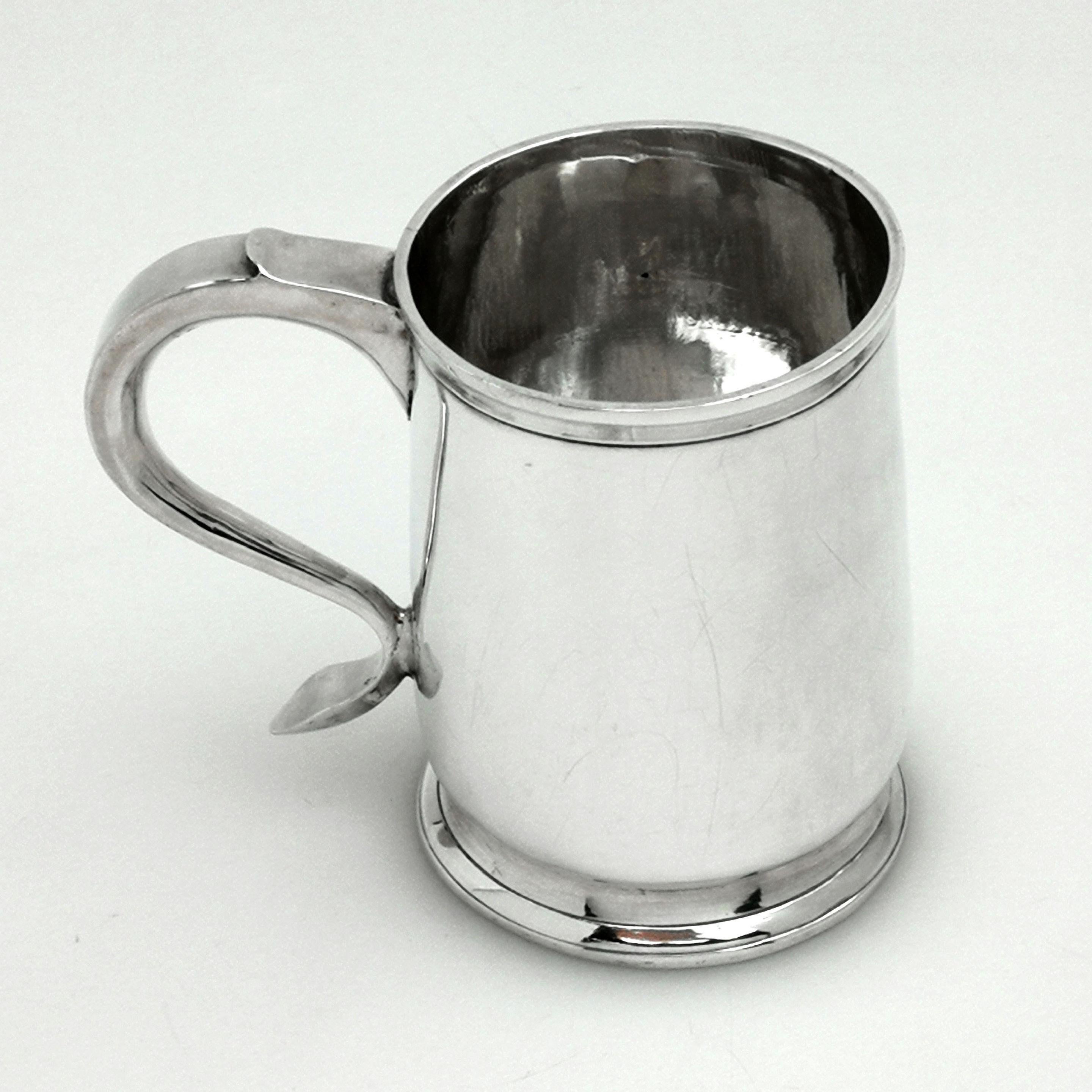 A Classic George II antique sterling silver Christening mug in a simple, elegant design so typical of the Georgian Period. The mug has a substantial scroll handle and stands on a spread foot. It is otherwise unembellished and features a polished