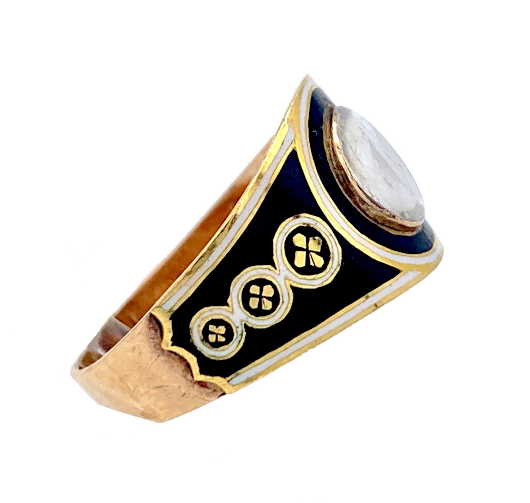  This elegant Georgian mourning ring was made in England in 1800 ca out of 15 karat yellow and rose gold and is decorated with black and white enamel. The front of the ring is designed as a large black and white circle with a domed glass in the