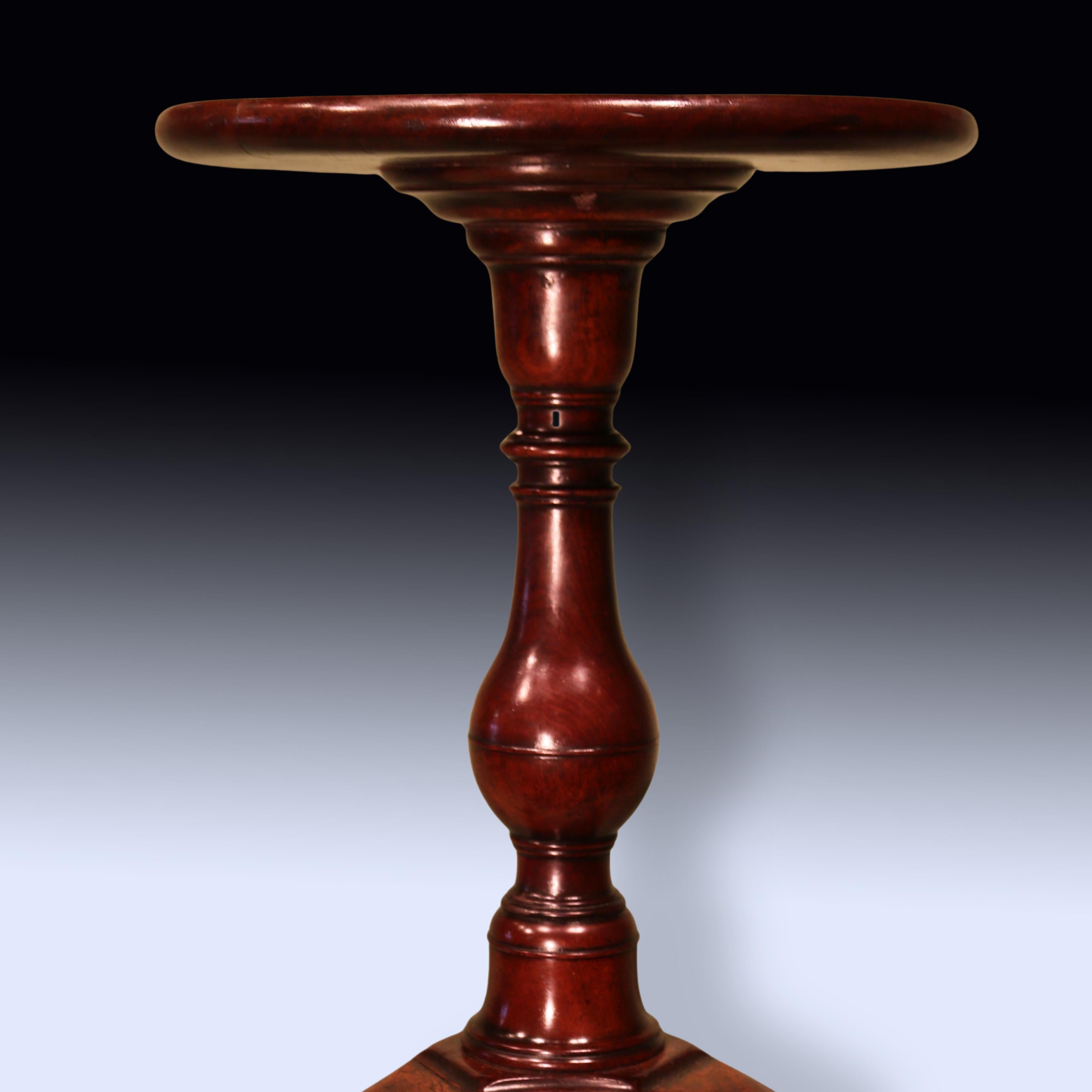 Bouilloire en acajou de couleur dorée du milieu du XVIIIe siècle, avec un plateau circulaire à bords moulés reposant sur une tige balustre à anneaux tournés et se terminant par des pieds cabriole avec des pattes en coussinet.