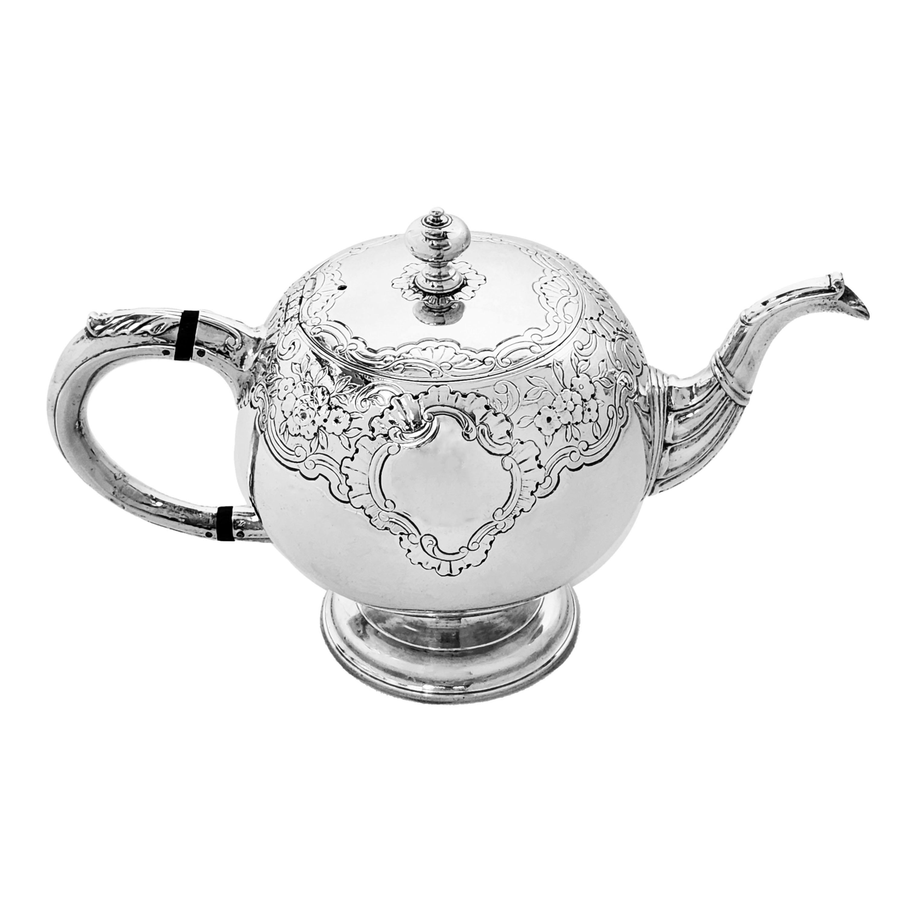 Eine schöne antike Teekanne aus schottischem Silber von George II in klassischer runder Kugelform. Diese georgianische Teekanne ist mit einem schönen gravierten Muster aus Blumen- und Schneckenmustern verziert, die ein Kartuschenpaar