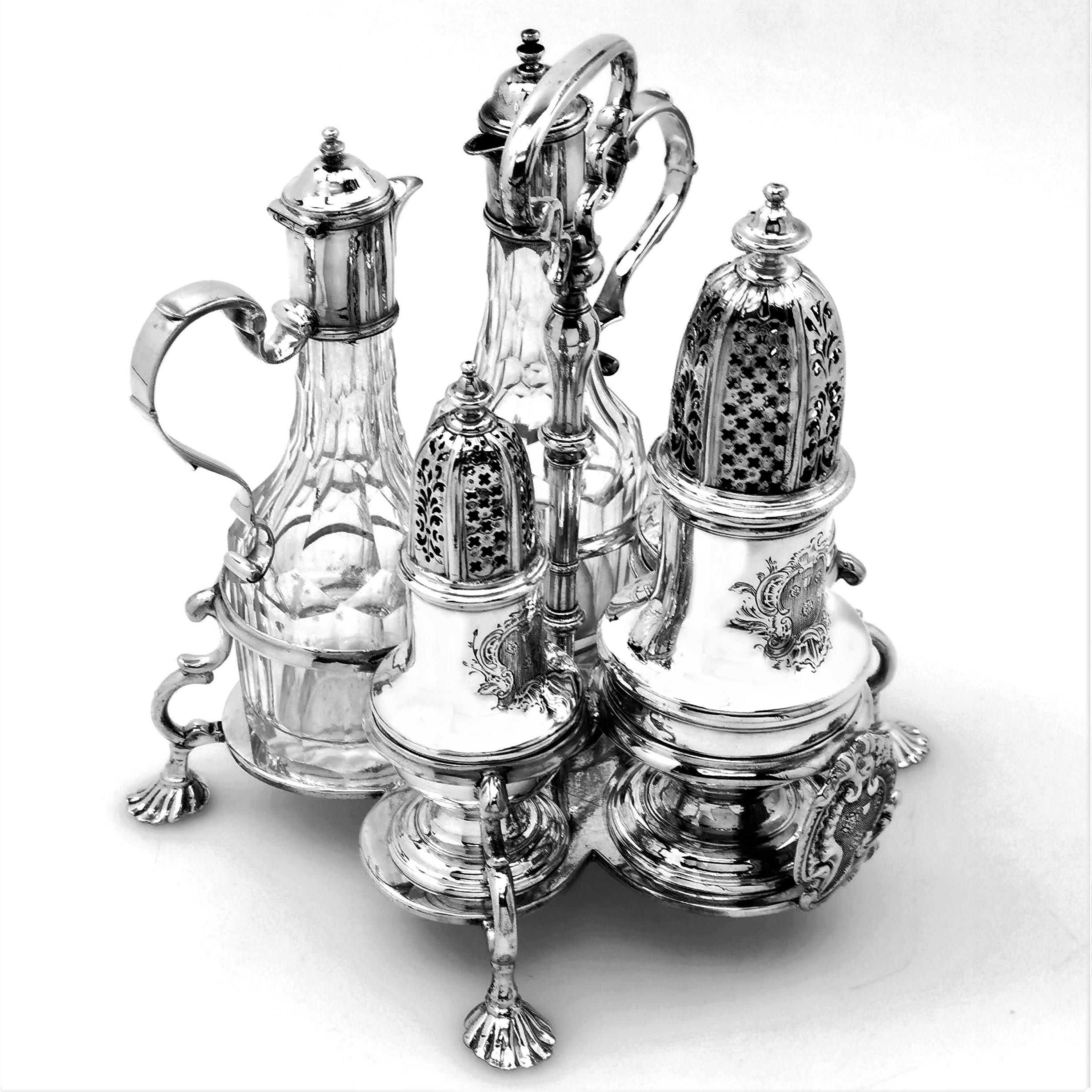 A classic Antique George II sterling Silver Cruet Stand in the traditional 'Warwick' style after the set originally created for the Earl of Warwick. The Cruet Stand contains a set of five Condiment containers including a pair of cut glass oil &