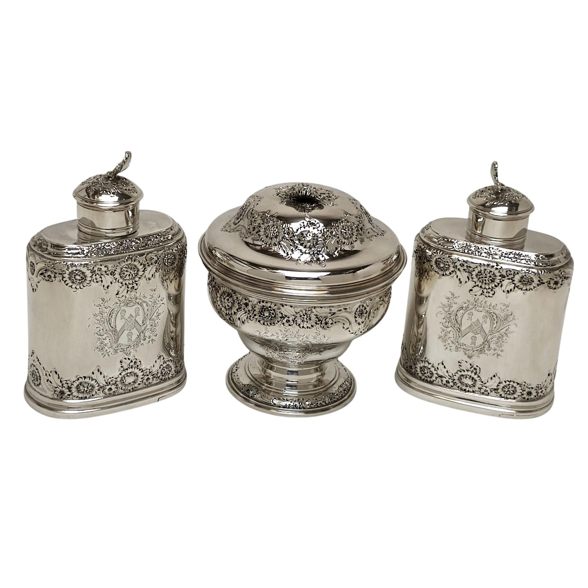 Un bellissimo set di 3 antichi caddie d'argento di Giorgio II in una custodia di legno. Questo set comprende una coppia di  porta tè d'argento dai lati dritti e una zuccheriera rotonda con coperchio a cupola. Ogni Caddy è impreziosito da bande di