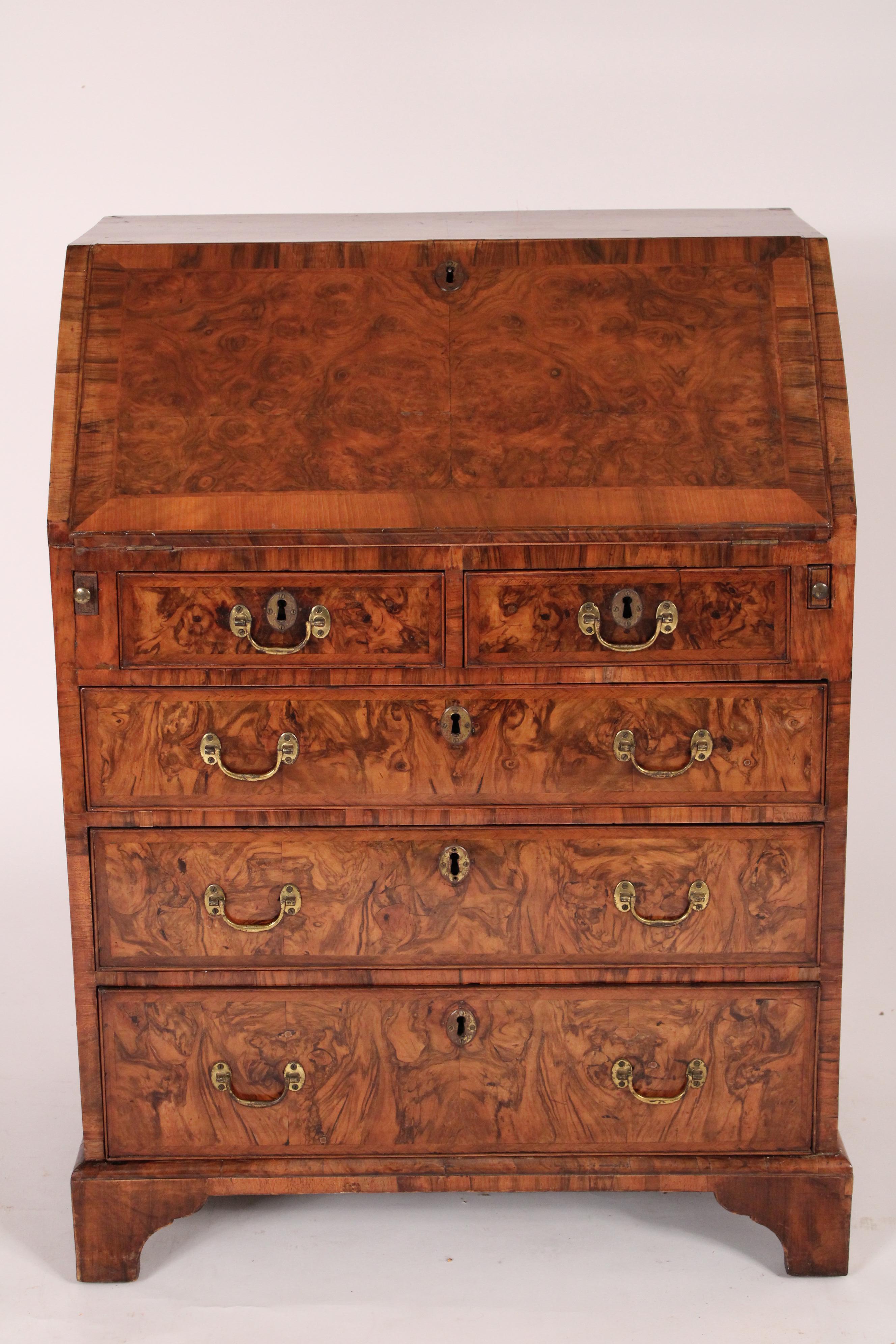 Antique George II style burl walnut and walnut slant top desk, late 19th century. With a burled walnut top, burled walnut slant top with herringbone inlay, when the slant top is opened there is a leather writing surface a long central drawer flanked