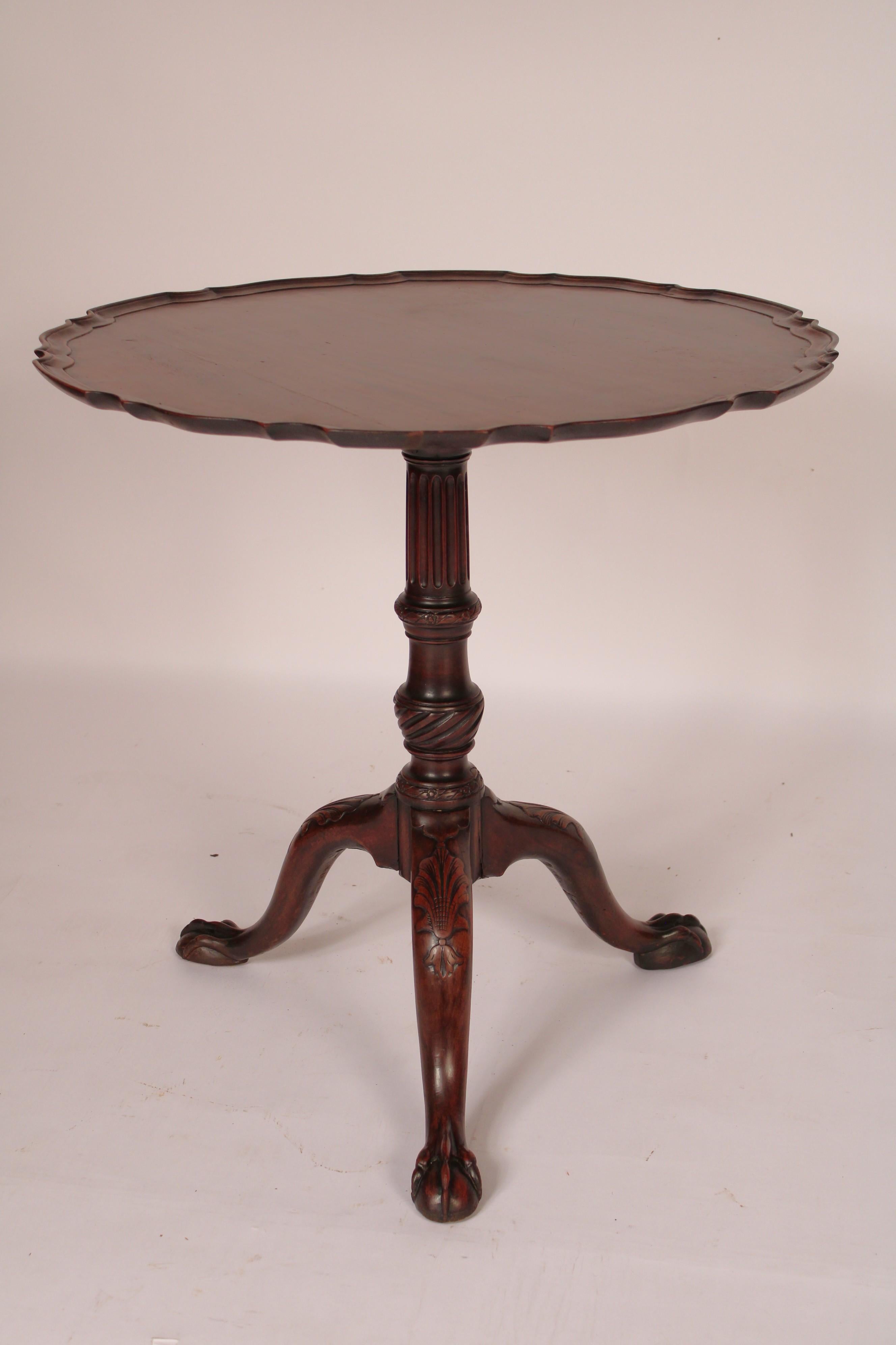 Antique George II style mahogany tilt top table, 19th century. With a nicely figured two board mahogany top with pie crust edge, a fluted and turned pedestal, 3 down swept legs with shell carved knees ending in ball and claw feet. This table has a