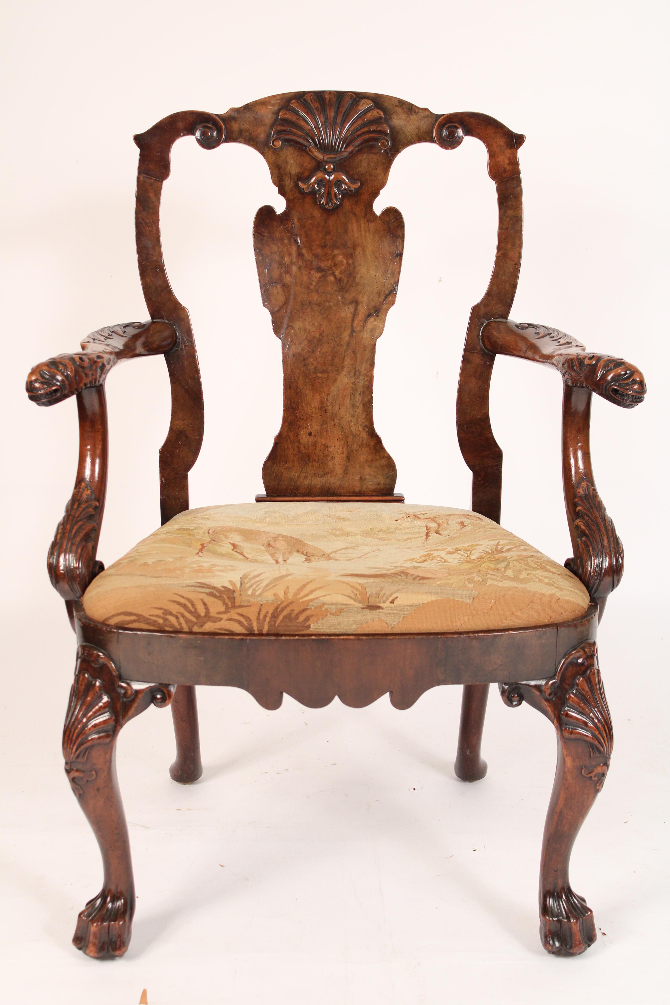 Antique George II style carved walnut armchair, 18th century and later. With a cupids bow crest rail with central shell carving, burl walnut vase shaped back splat, arms terminating in mythological animal heads, cabriole legs with shell carved knees