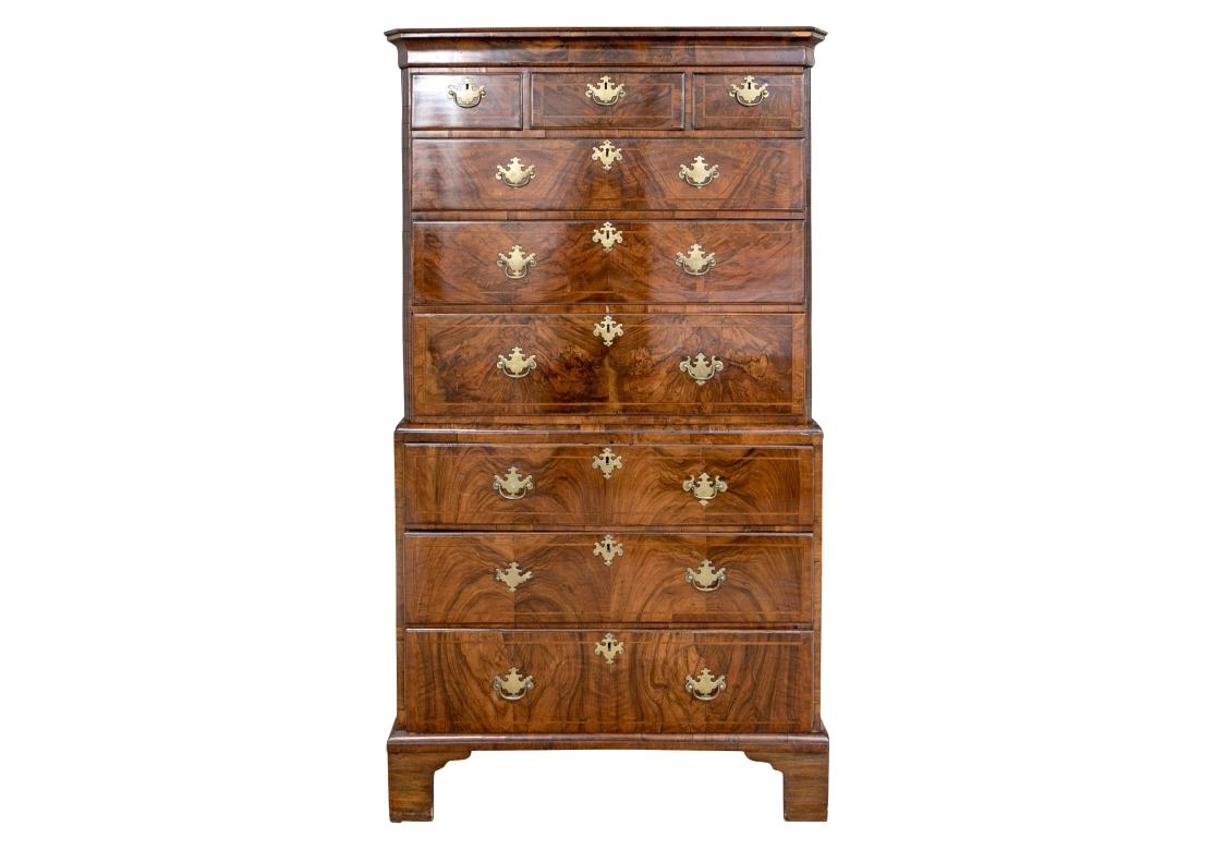 An antique Georgian walnut chest on chest with three short drawers below a moulded crown above three long drawers in the upper cabinet and over 3 long drawers in the lower case. The drawers flanked by fluted and cantered side panels and the whole