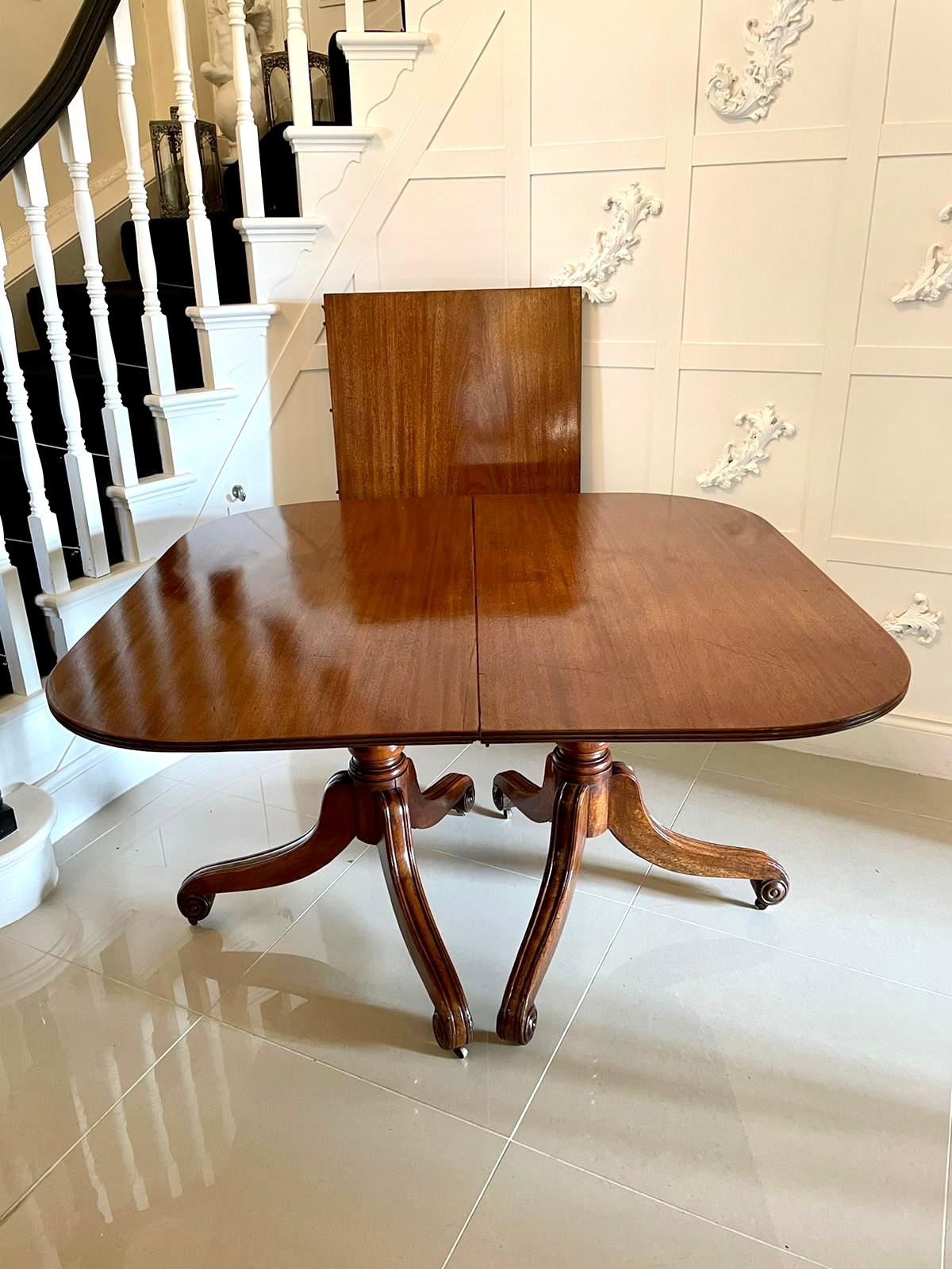 Antique fine quality George III antique mahogany twin pedestal dining table having a quality mahogany top in with one original extra leaf, supported by two original mahogany pedestals with a turned column, raised on three shaped saber legs with